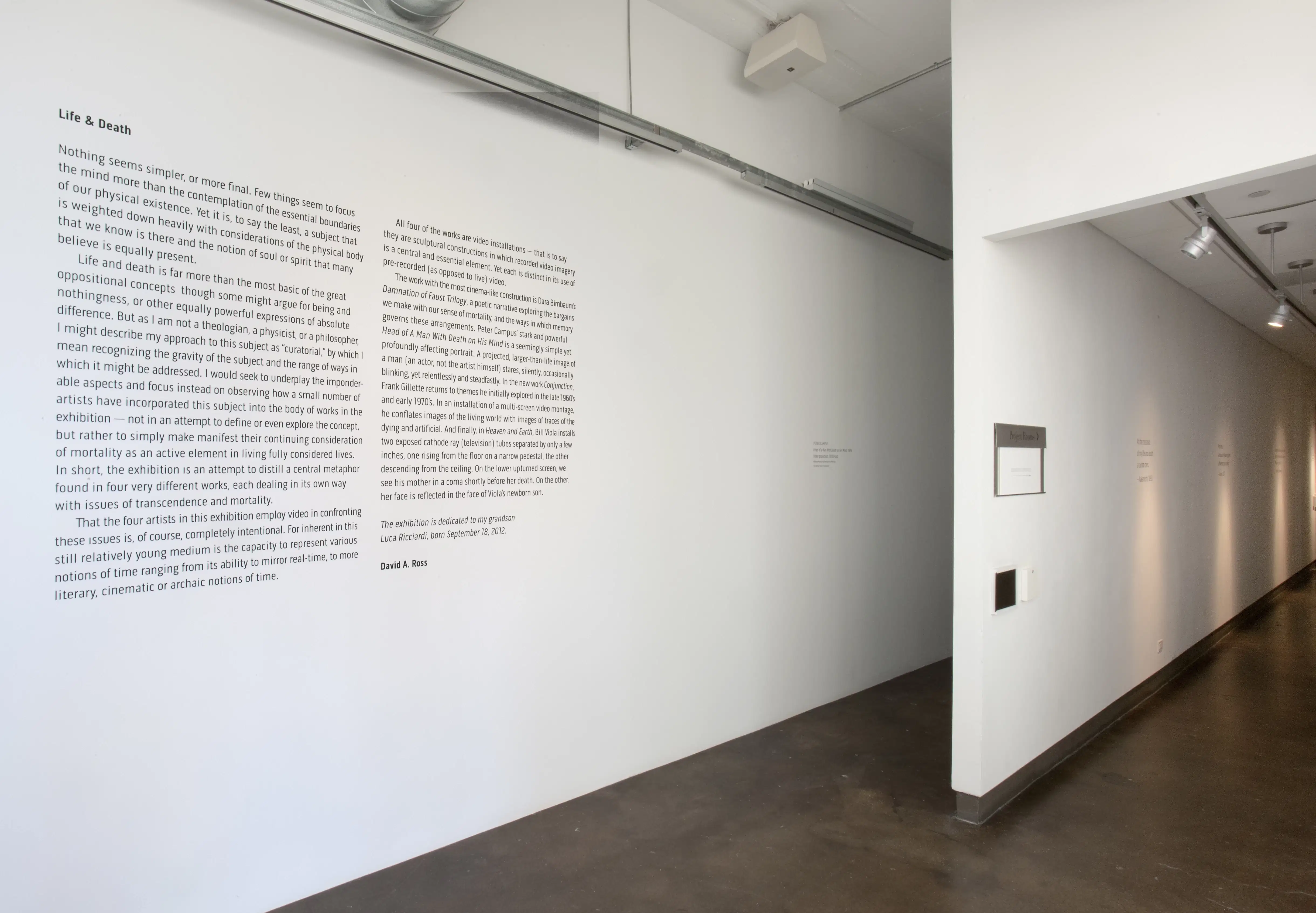 An exhibit wall with an article about life and death.