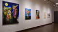 A row of five paintings hung in a horizontal row on the wall using abstract and volumetric shapes to create bouquets of flowers and other forms.