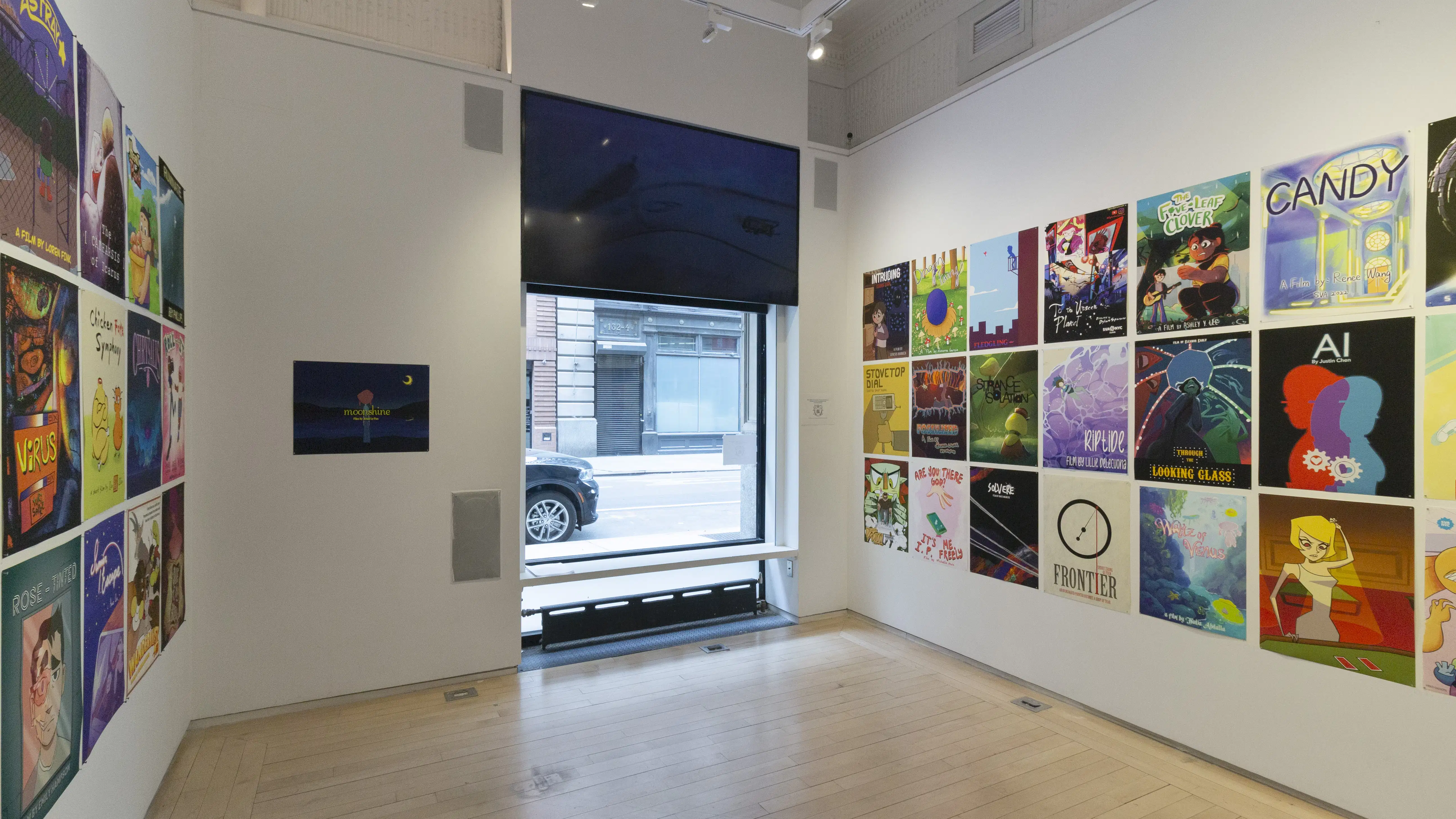 Multiple views of SVA Flatiron Windows and Flatiron Project Space. There are monitors hung in the Windows with films playing and film posters hung in the Flatiron Project Space.