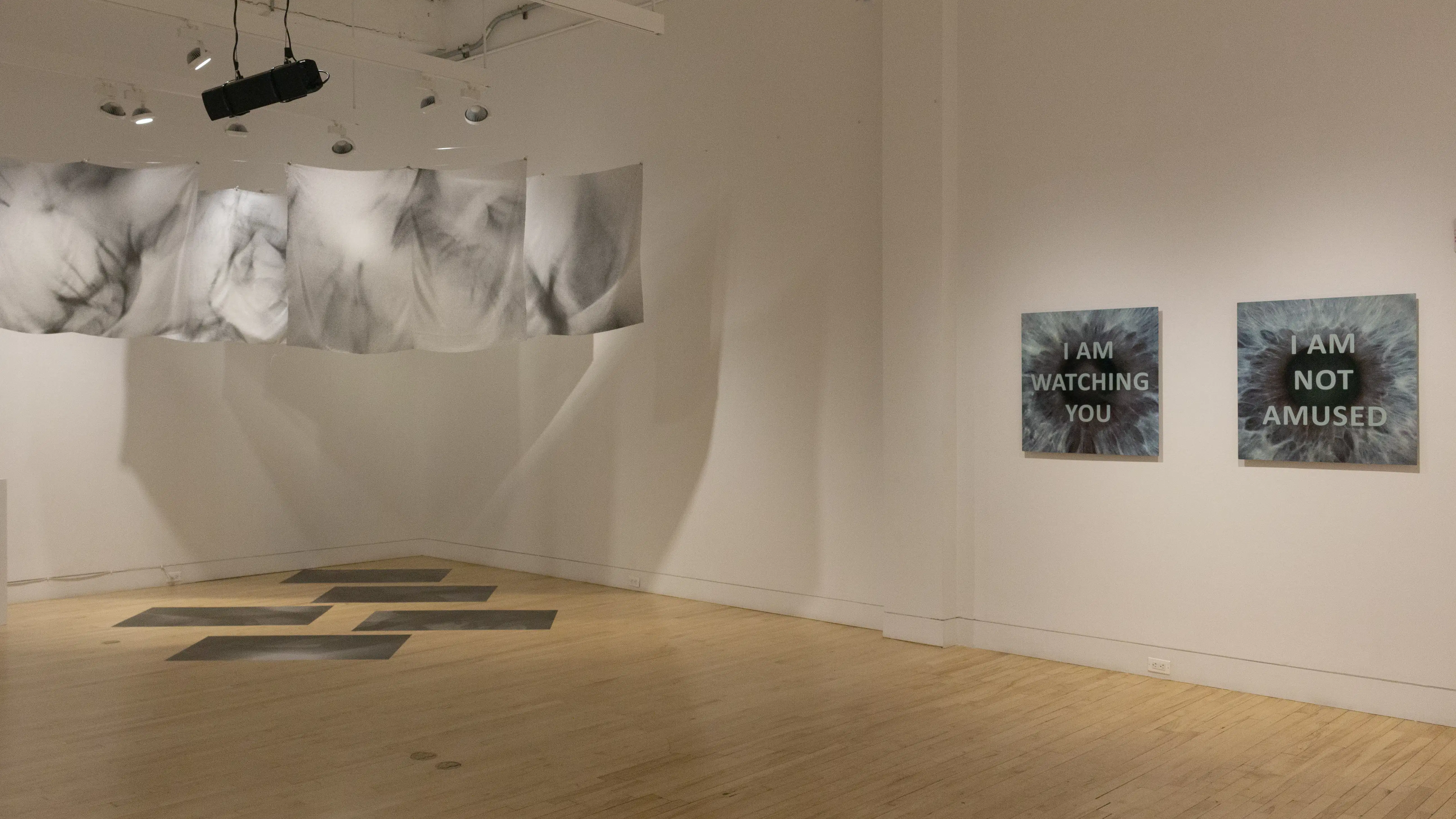 Multiple views of SVA Flatiron Gallery and Windows with installation, photographs, and textile throughout the gallery. 