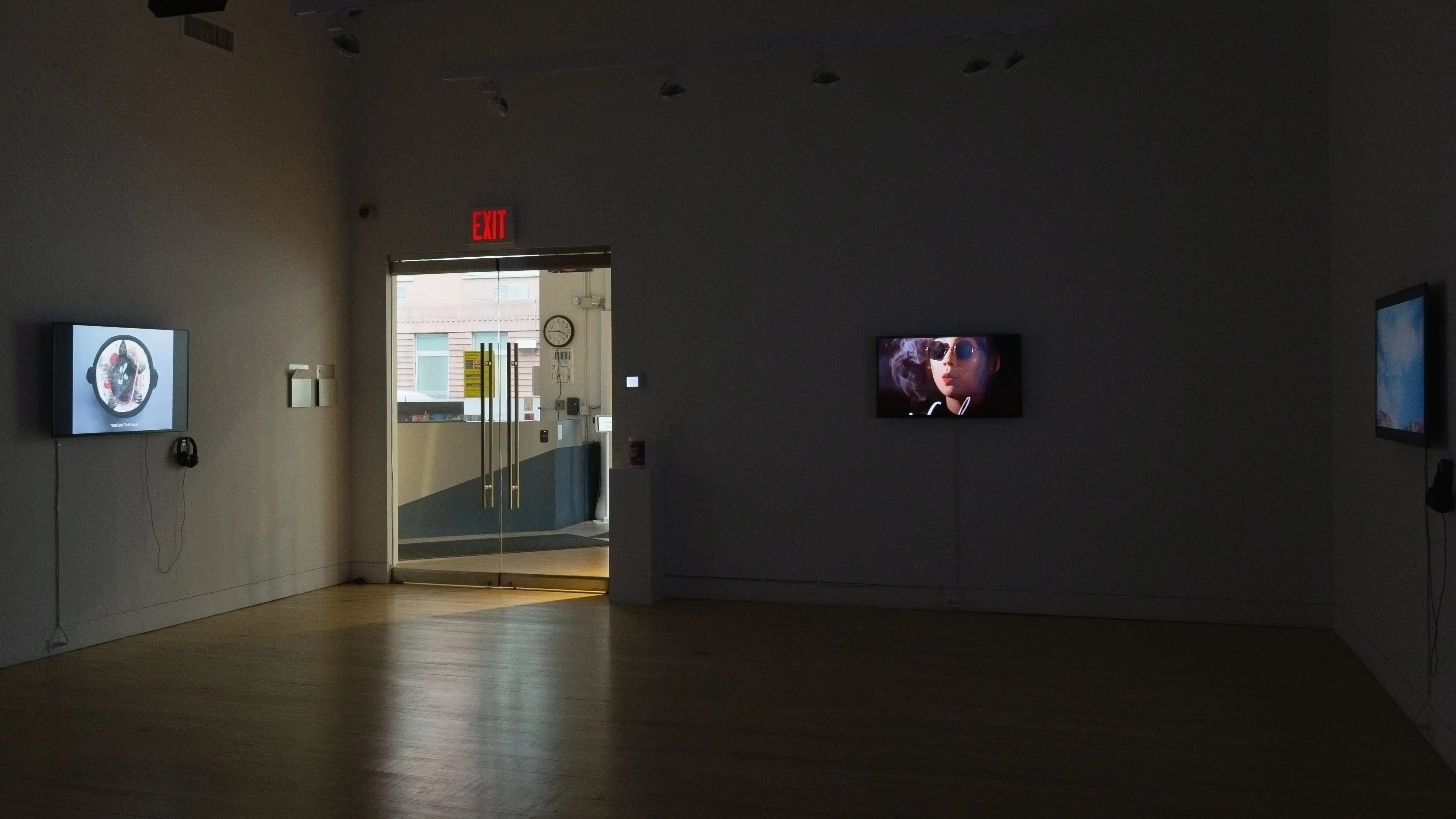 Multiple views of SVA Flatiron Gallery. There are three monitors playing various videos on the wall and an interactive projection. 
