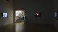 Multiple views of SVA Flatiron Gallery. There are three monitors playing various videos on the wall and an interactive projection. 