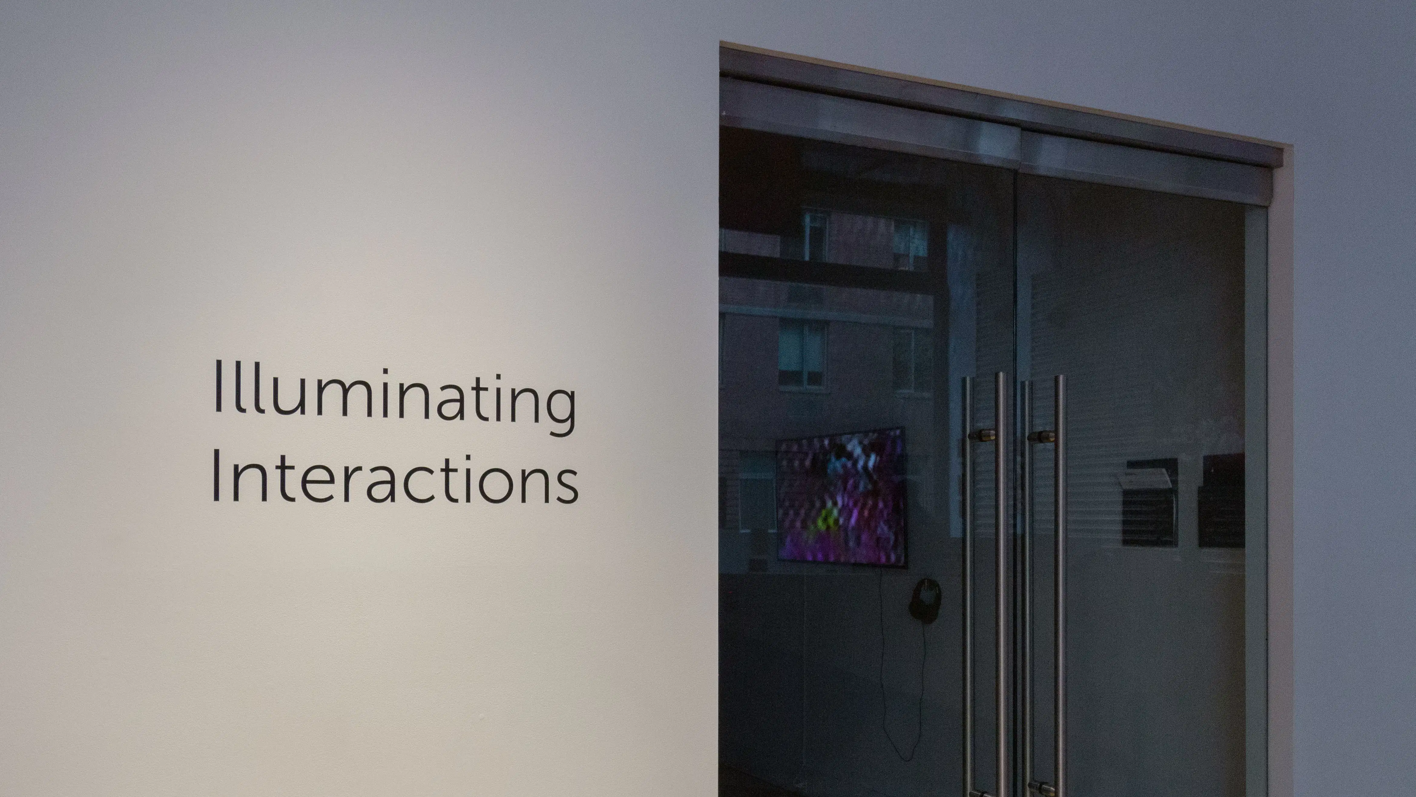 Multiple views of SVA Flatiron Gallery. There are three monitors playing various videos on the wall and an interactive projection. 