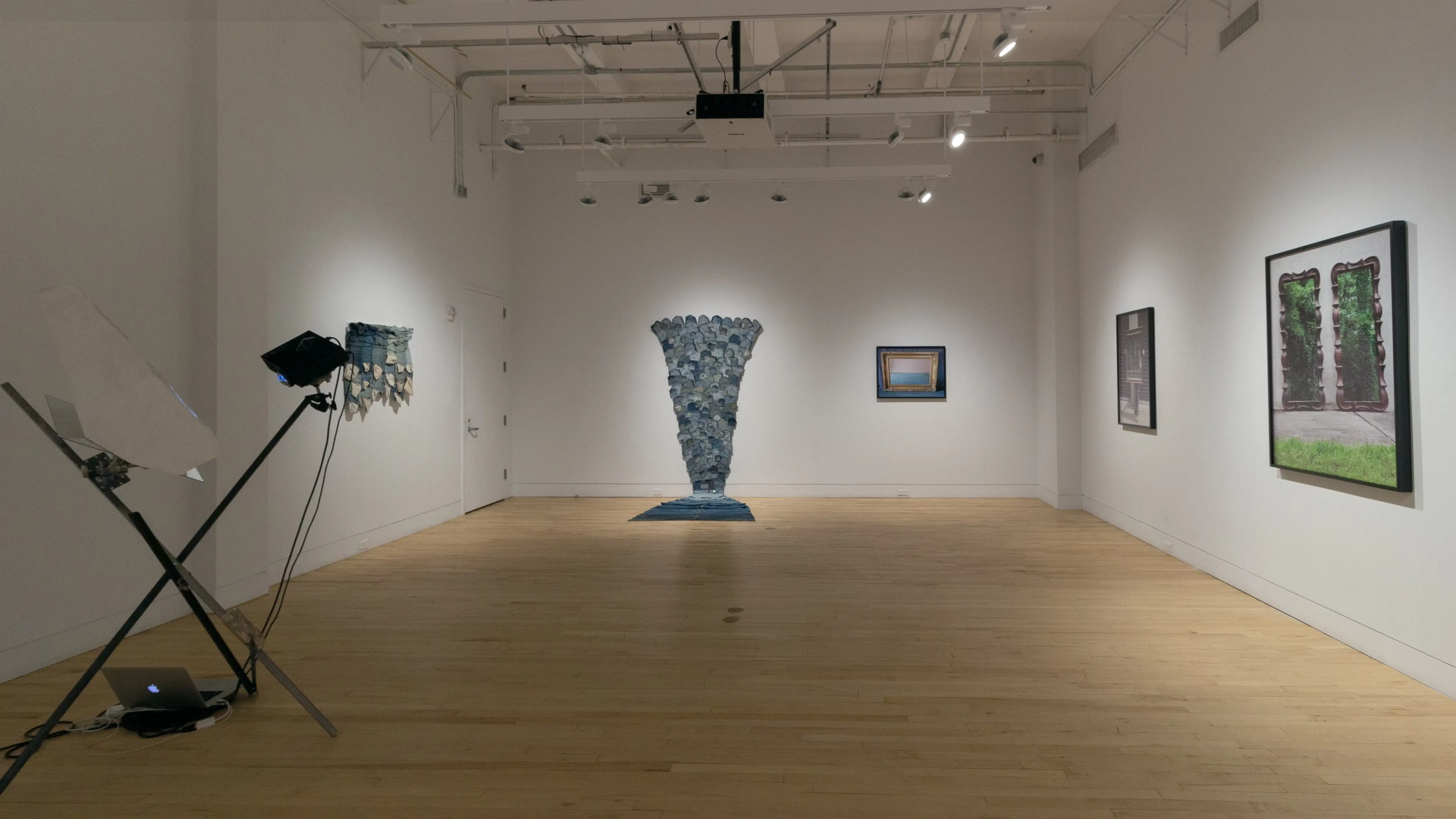 Multiple views of SVA Flatiron Gallery and Windows. There are photographs, collages, and installation work throughout the gallery and displayed in the windows. 