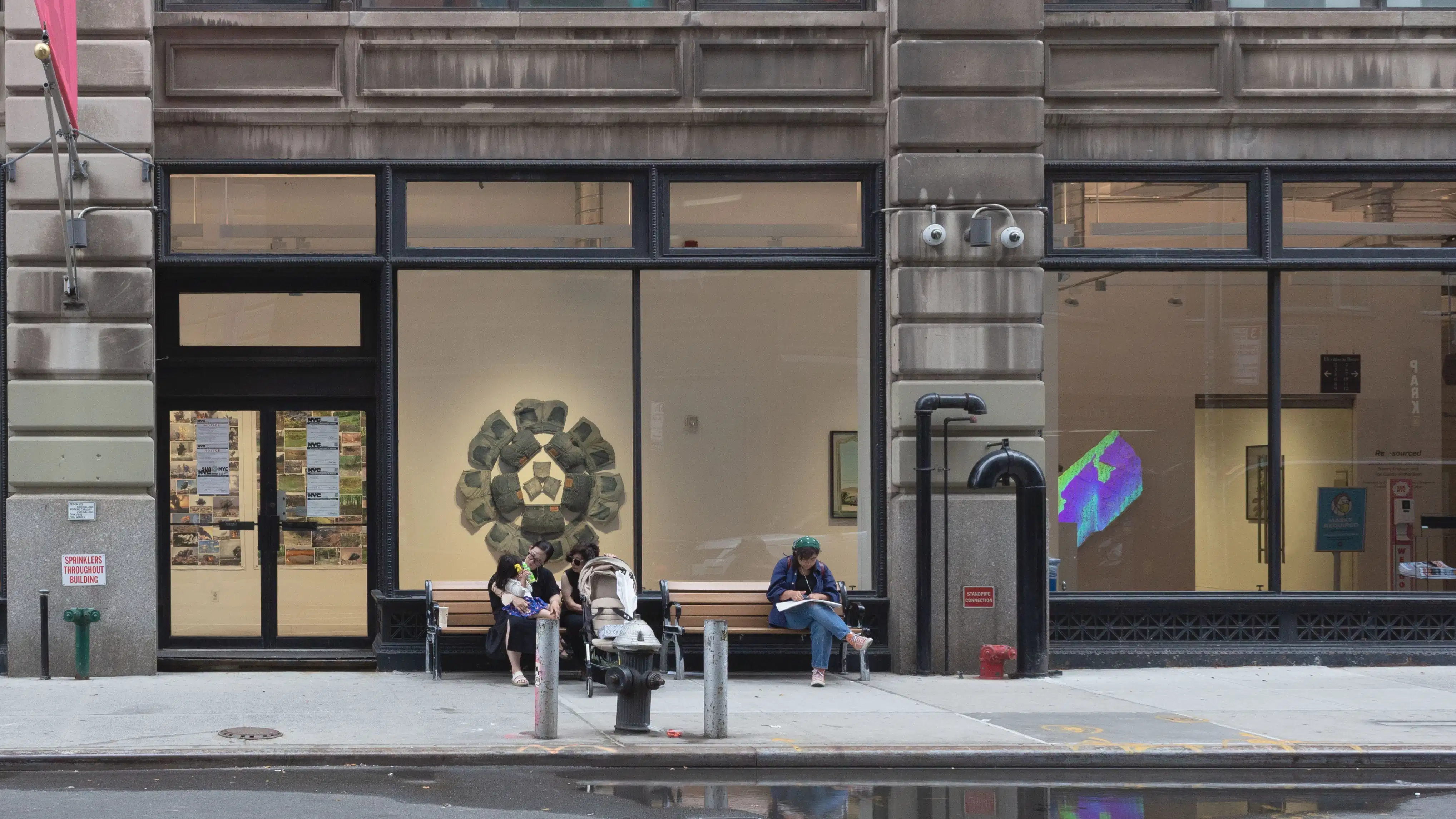 Multiple views of SVA Flatiron Gallery and Windows. There are photographs, collages, and installation work throughout the gallery and displayed in the windows. 