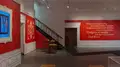 Multiple views of SVA Gramercy Gallery. The lobby is pained red with "Spring Salon" in ornate lettering and the gallery is painted blue. There are monitors in ornate frames playing student work through the gallery. In the center of the lobby and gallery are metal pedestals with student work on them. 