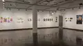 Multiple views of SVA Chelsea Gallery. There is illustrations and paintings hung on the walls. There are multiple shelves throughout the gallery with books places on them.