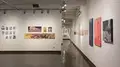 Multiple views of SVA Chelsea Gallery. There is illustrations and paintings hung on the walls. There are multiple shelves throughout the gallery with books places on them.