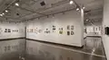 Multiple views of SVA Chelsea Gallery. There is illustrations and paintings hung on the walls. There are multiple shelves throughout the gallery with books places on them.