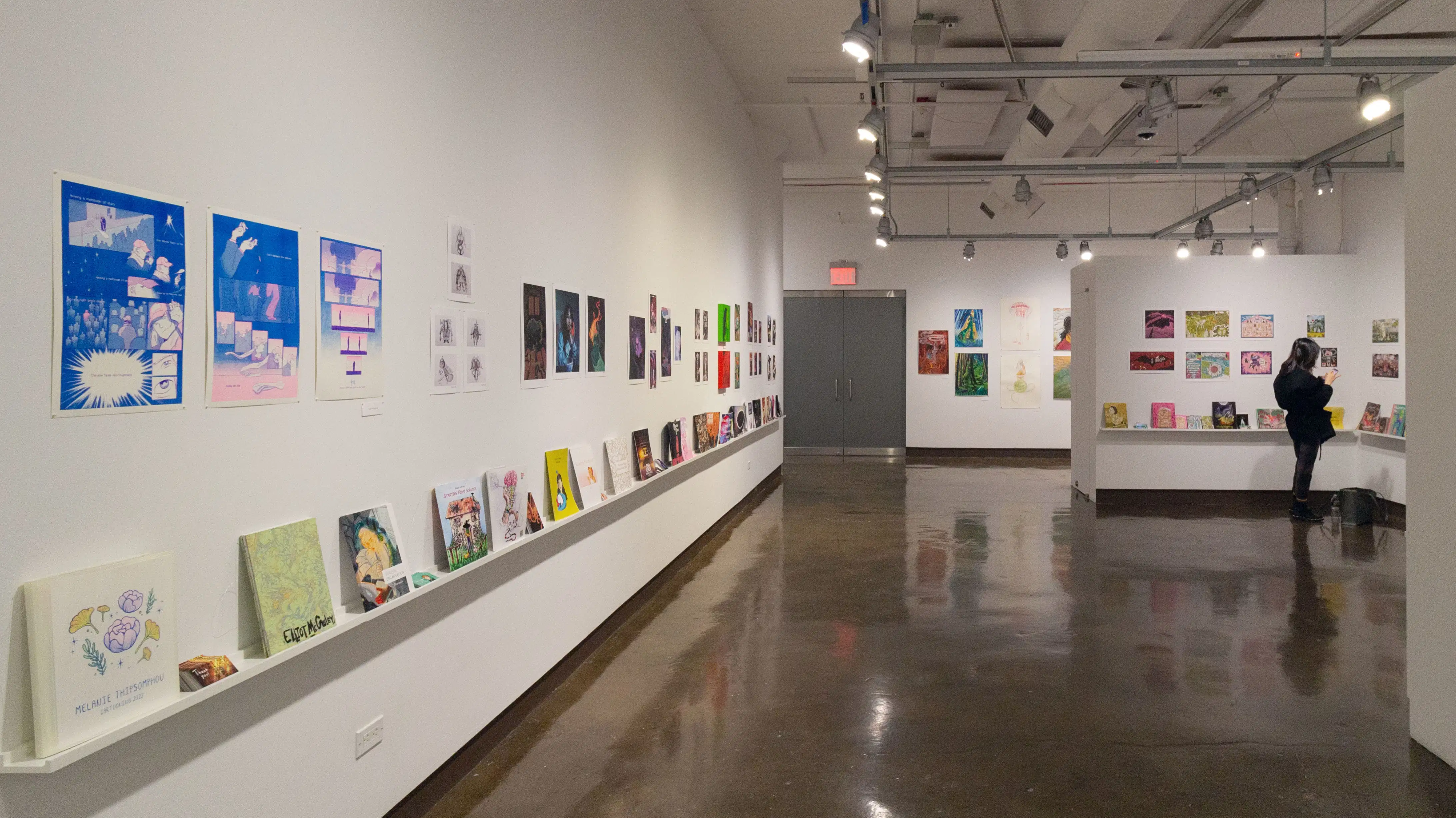 Multiple views of SVA Chelsea Gallery. There is illustrations and paintings hung on the walls. There are multiple shelves throughout the gallery with books places on them.