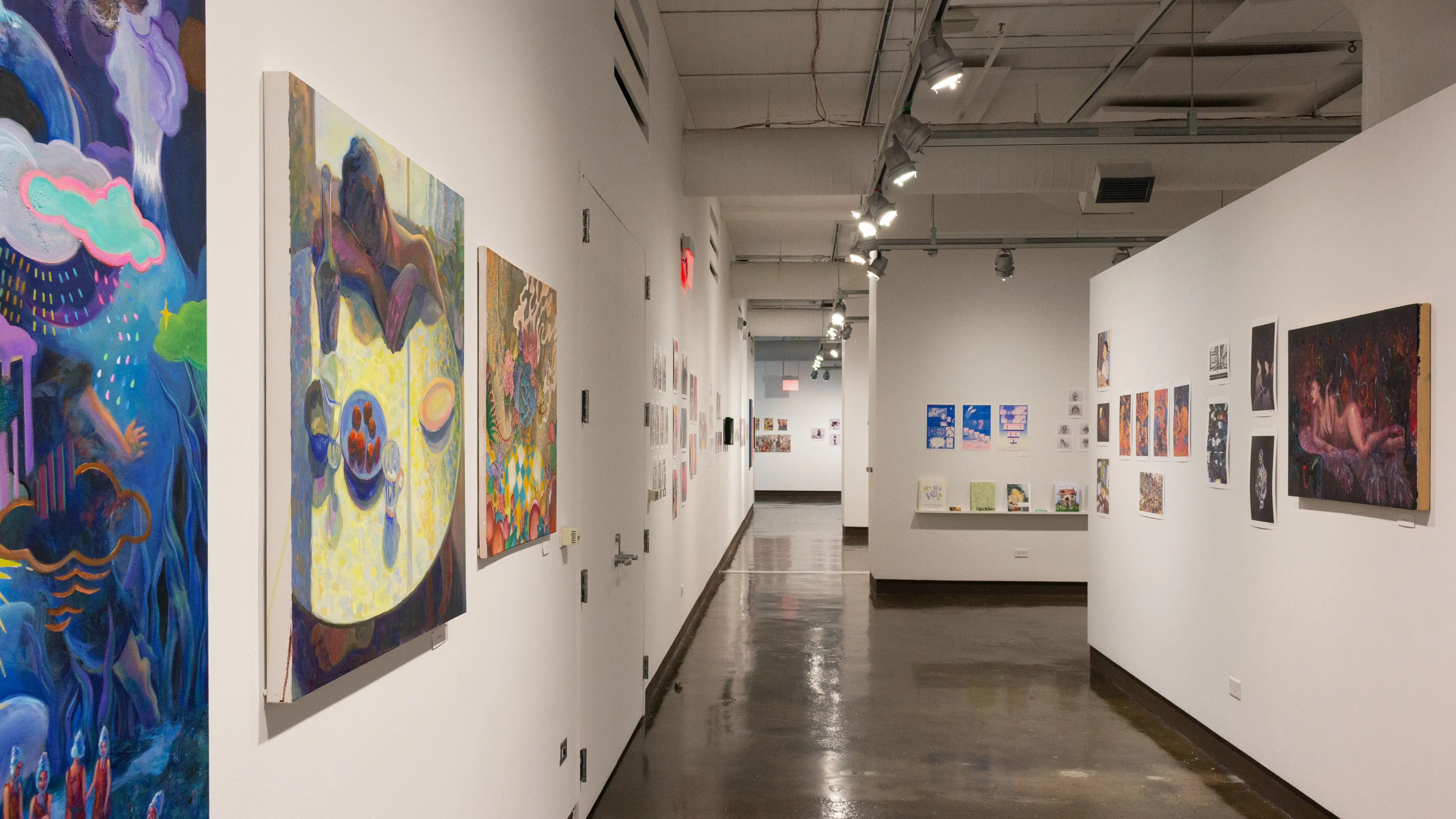 Multiple views of SVA Chelsea Gallery. There is illustrations and paintings hung on the walls. There are multiple shelves throughout the gallery with books places on them.