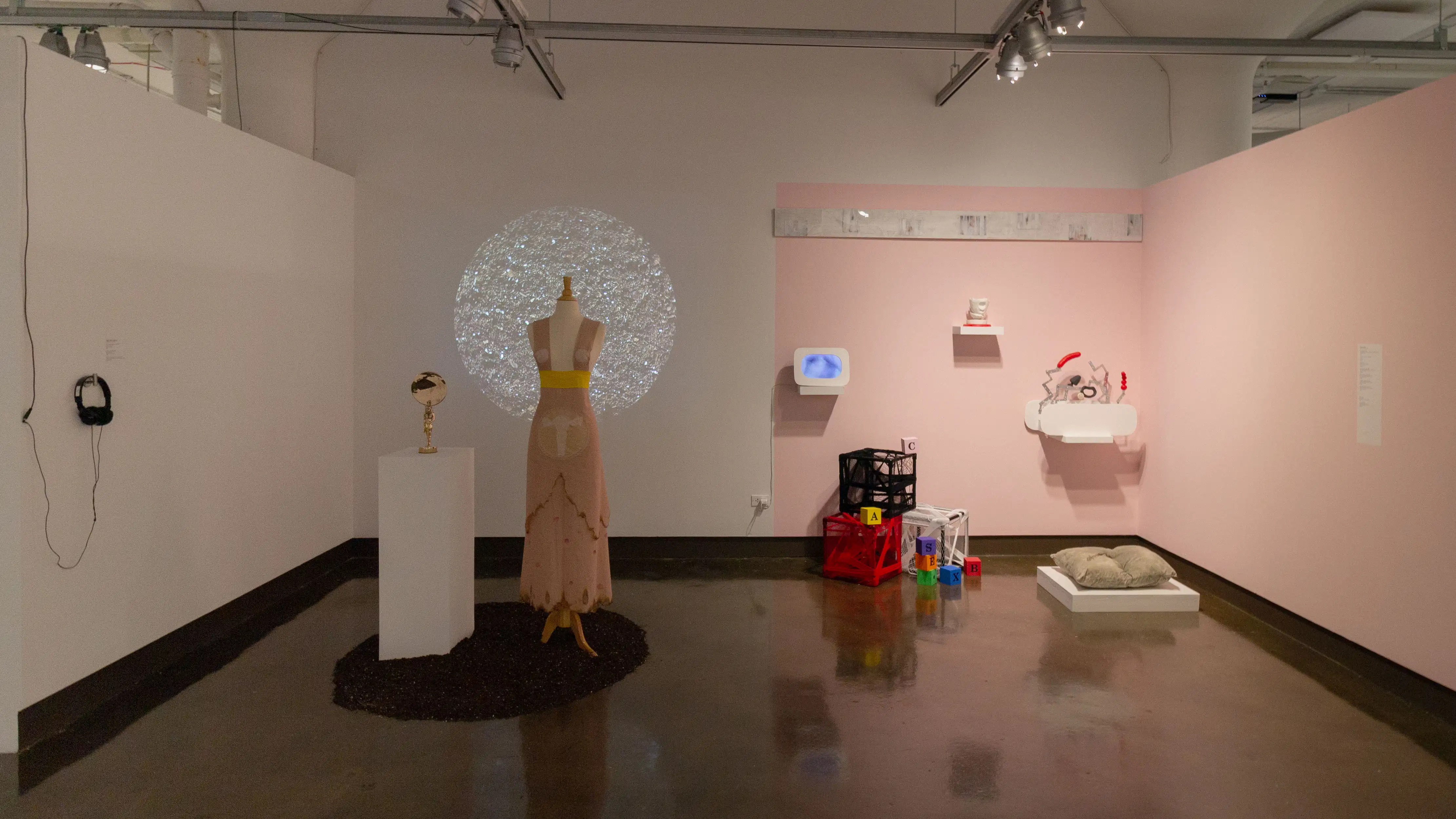 Multiple views of SVA Chelsea Gallery. There are photographs hung on the wall, installations and projections throughout the gallery. 