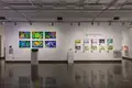 Multiple views of SVA Chelsea Gallery. There are illustrations, monitors, and paintings hung on the walls. Shelves have posters, books, CDs and artist take-aways.