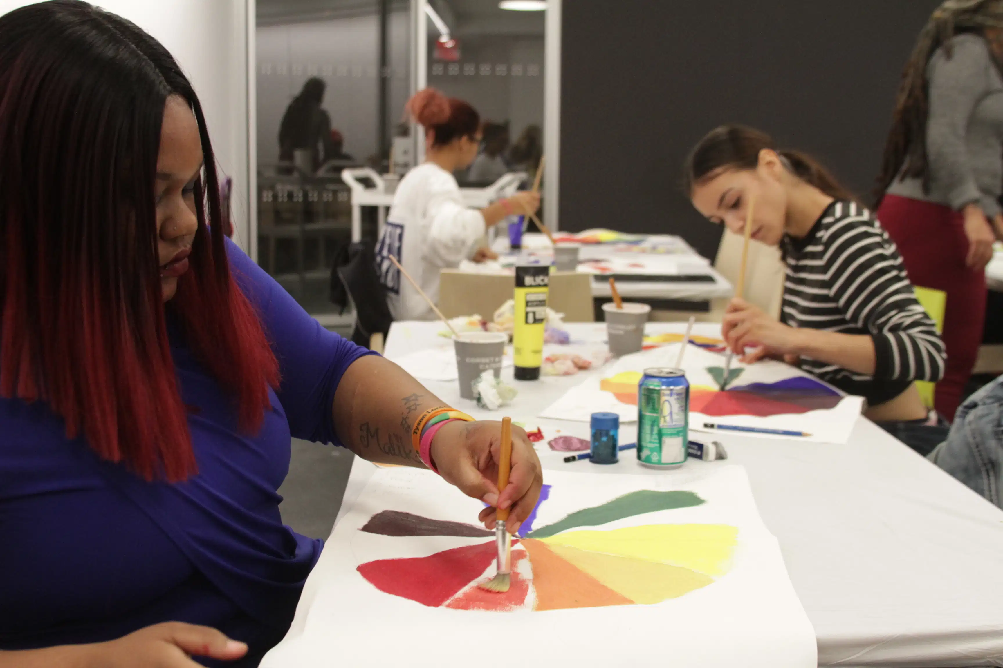 <p "="">A photo of Night Studio students painting color wheels.
