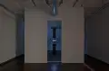 A simple art showcase in a room with two glowing objects.