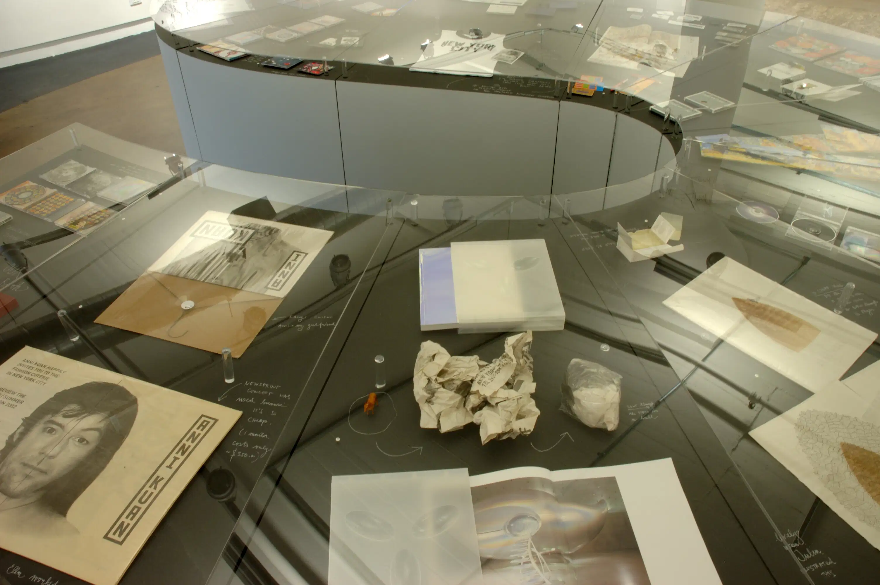 A crumpled sheet of paper on a glass surface display with other pages that have pictures on them.