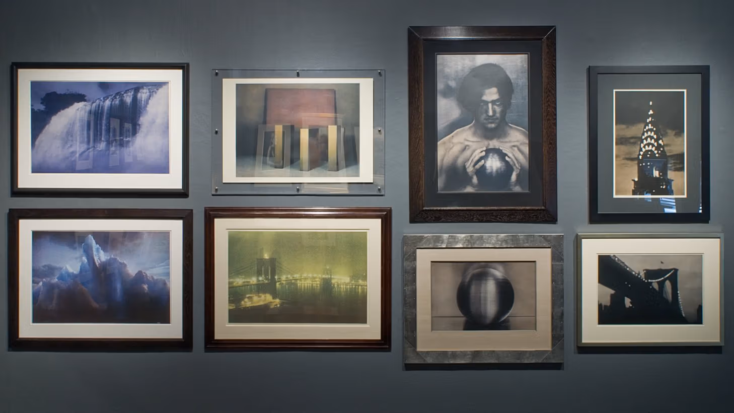 Framed photographs, slightly abstracted, of cityscapes, still lifes, and a man holding a metal orb.