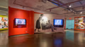 Photograph from inside SVA Chelsea Gallery with advertising graphics hung on walls.