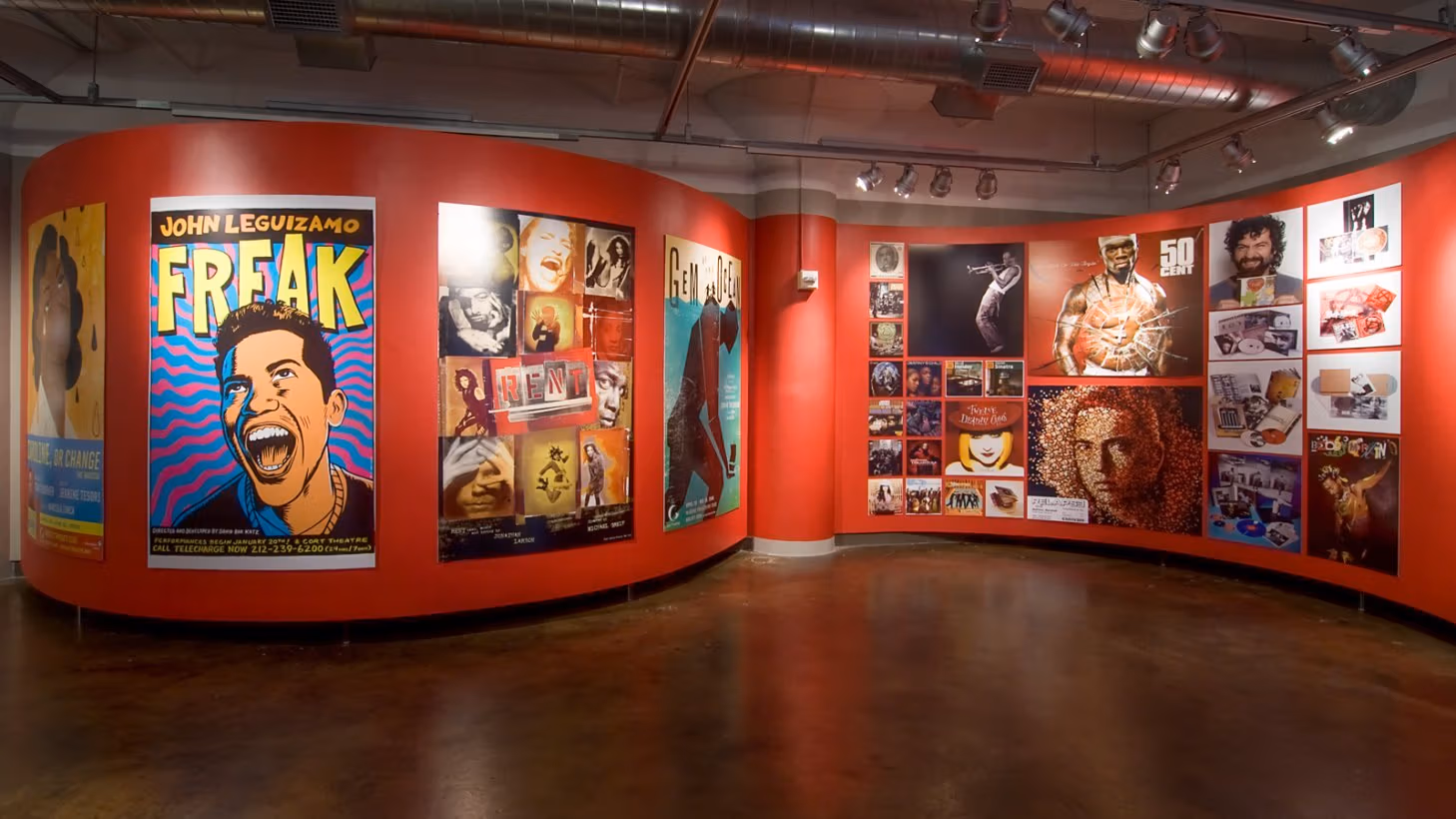 Photograph from inside SVA Chelsea Gallery with advertising graphics hung on walls.