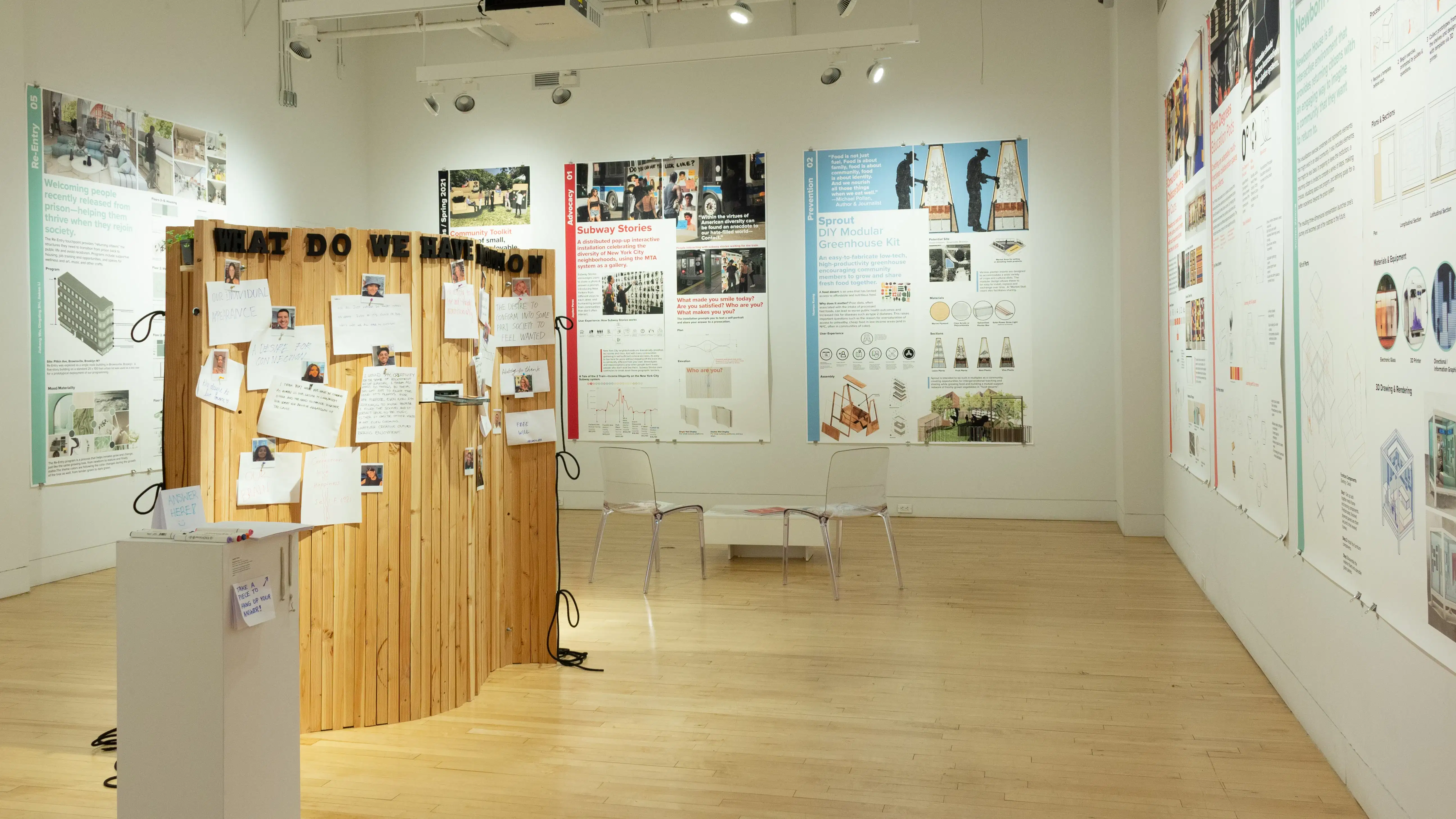 Exhibition view of An Infrastructure for Restorative Justice, featuring wooden sculpture and large posters on the walls.