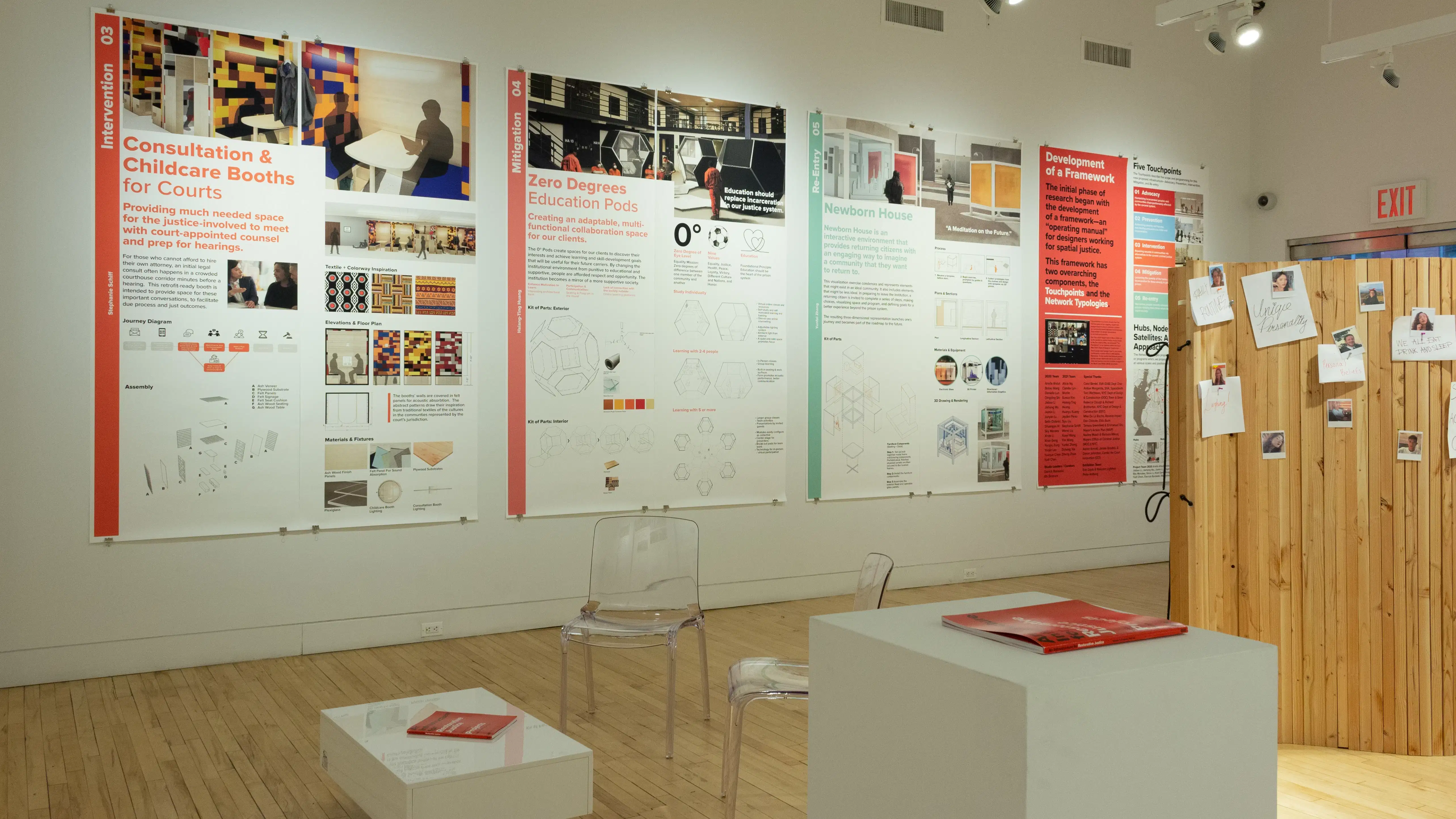 Exhibition view of An Infrastructure for Restorative Justice, featuring wooden sculpture and large posters on the walls.