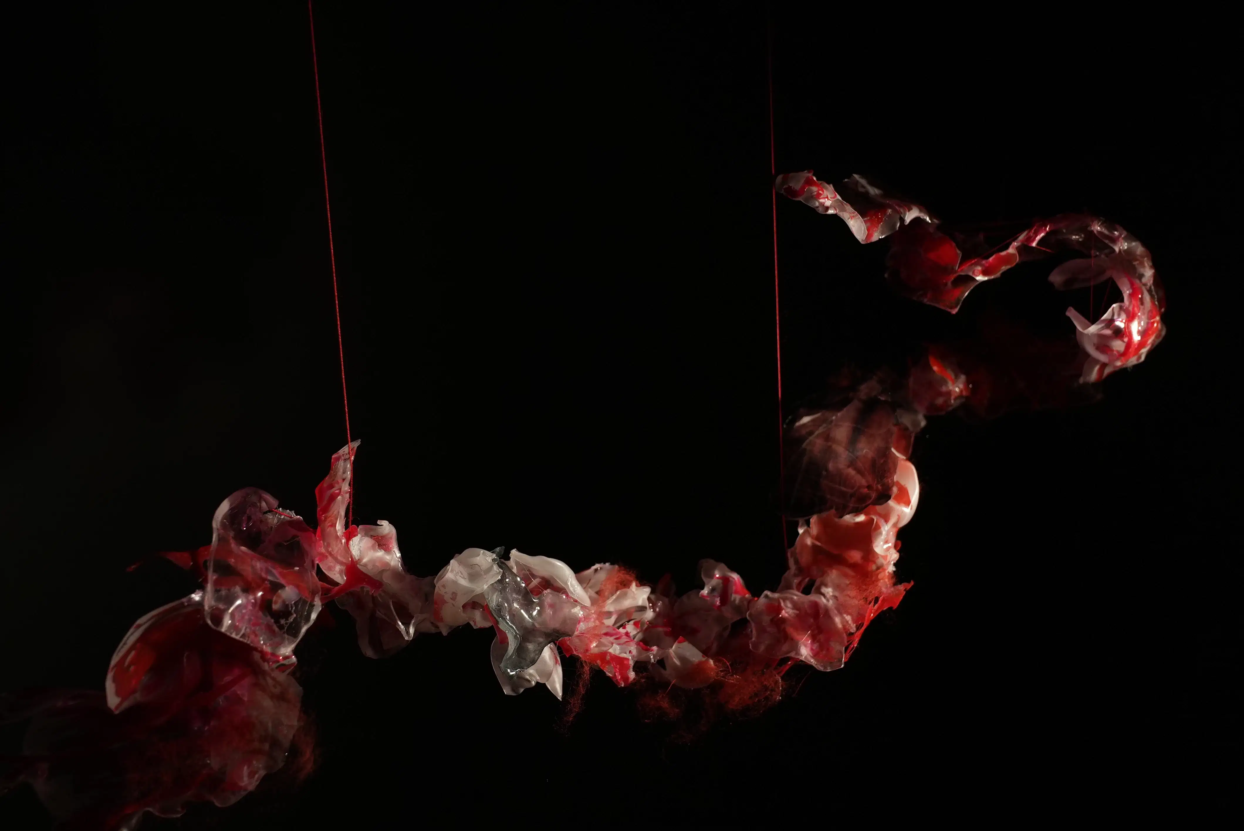 Art installation evoking the flow and connection of rivers and women's enduring kinship, through mixed media and symbolic threads.