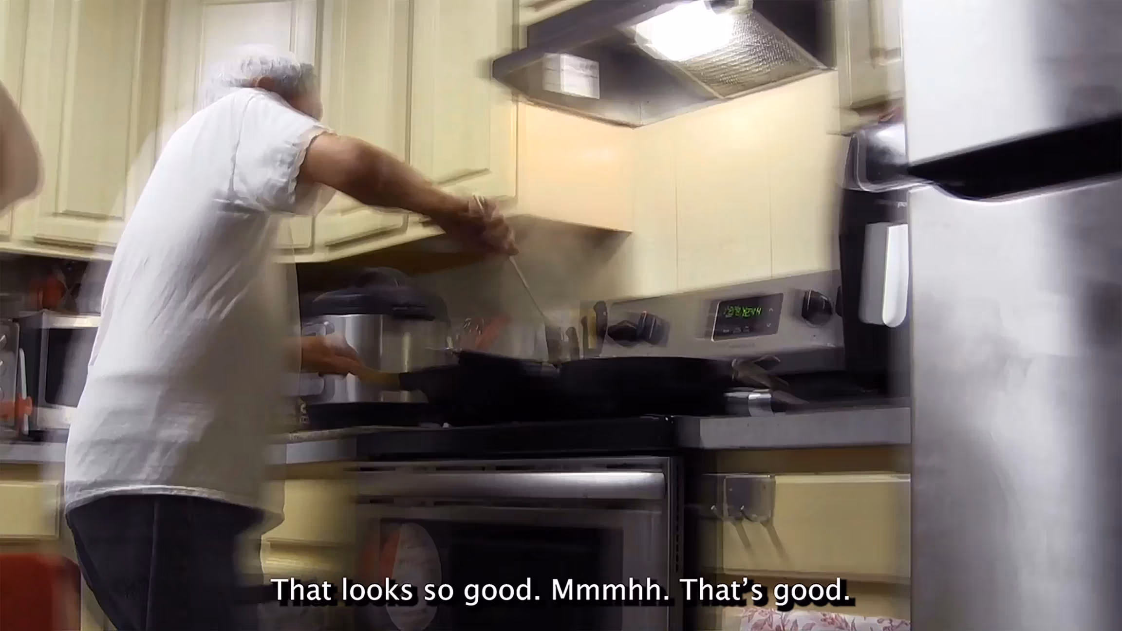 Blurry video still of person cooking in a kitchen