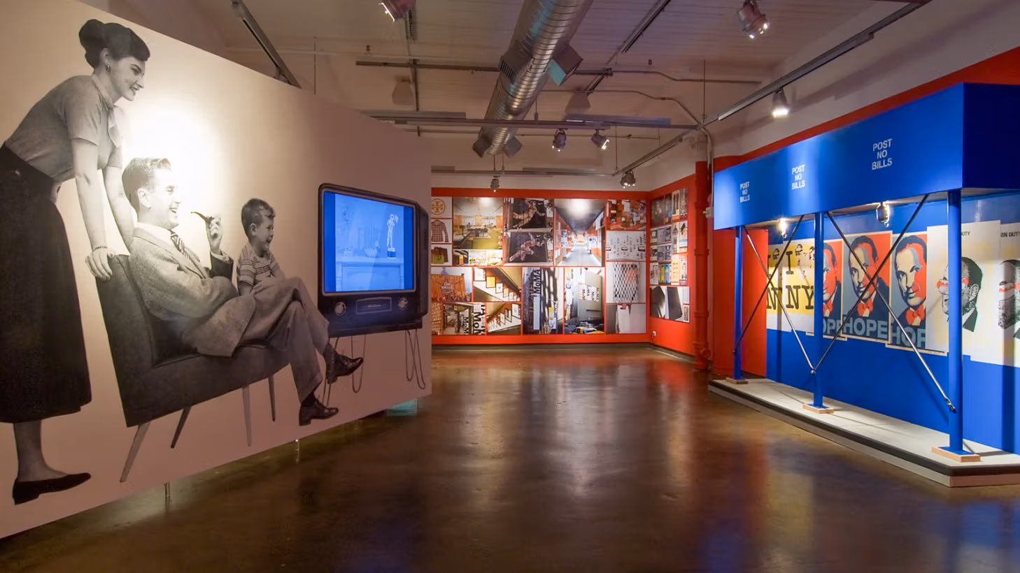 Photograph from inside SVA Chelsea Gallery with advertising graphics hung on walls.