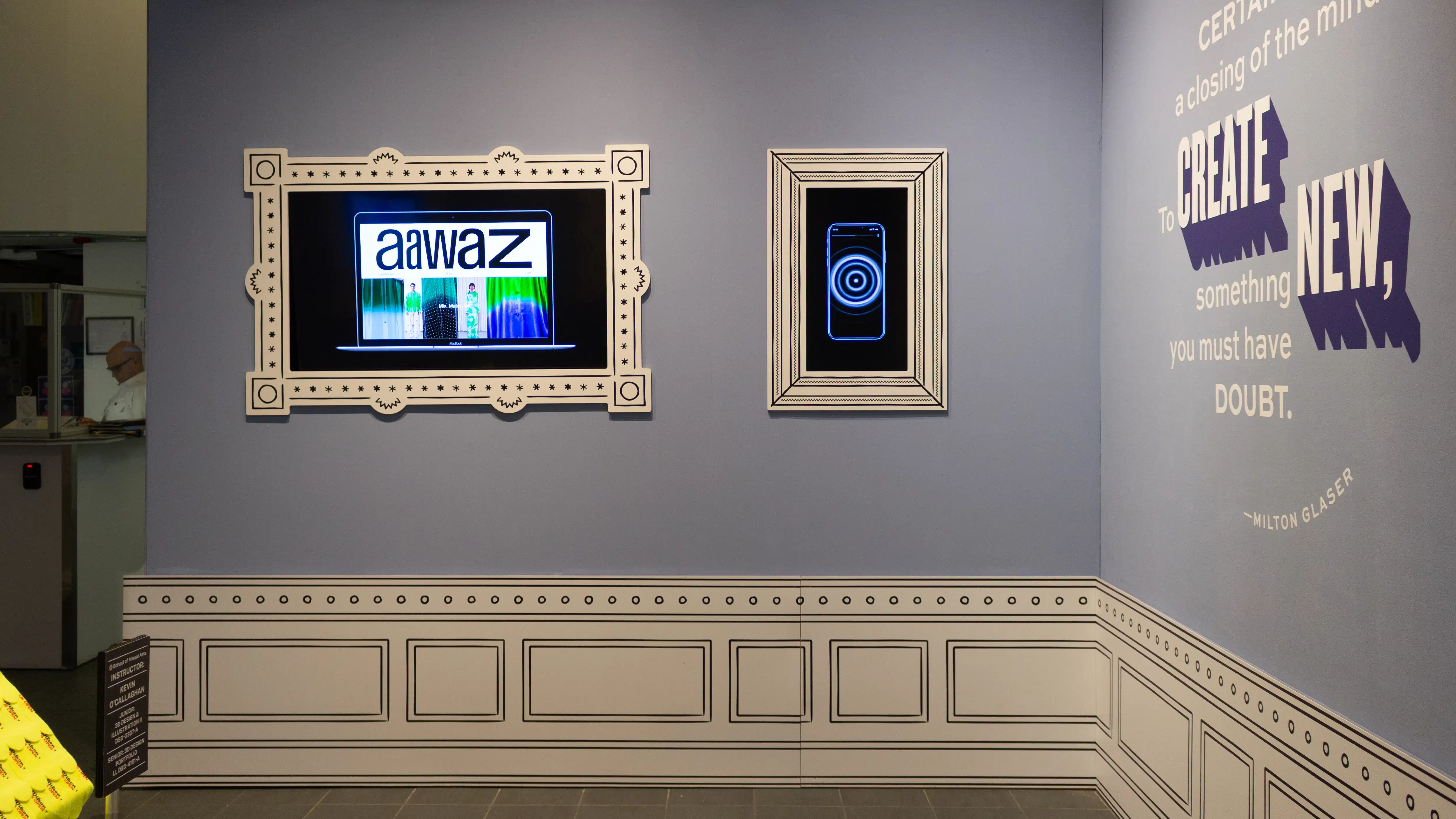 Installation image featuring a large room with two framed monitors on the walls.