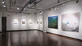 Exhibition photograph of “Between Picture and Viewer," with the five left-most paintings in neutral tones and the two on the right being colorful, fantastical depictions of an individual engaging with nature.