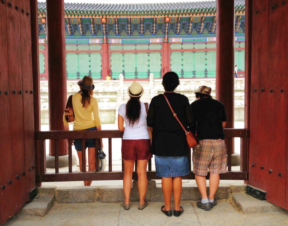Four people with their backs to the camera looking at a building