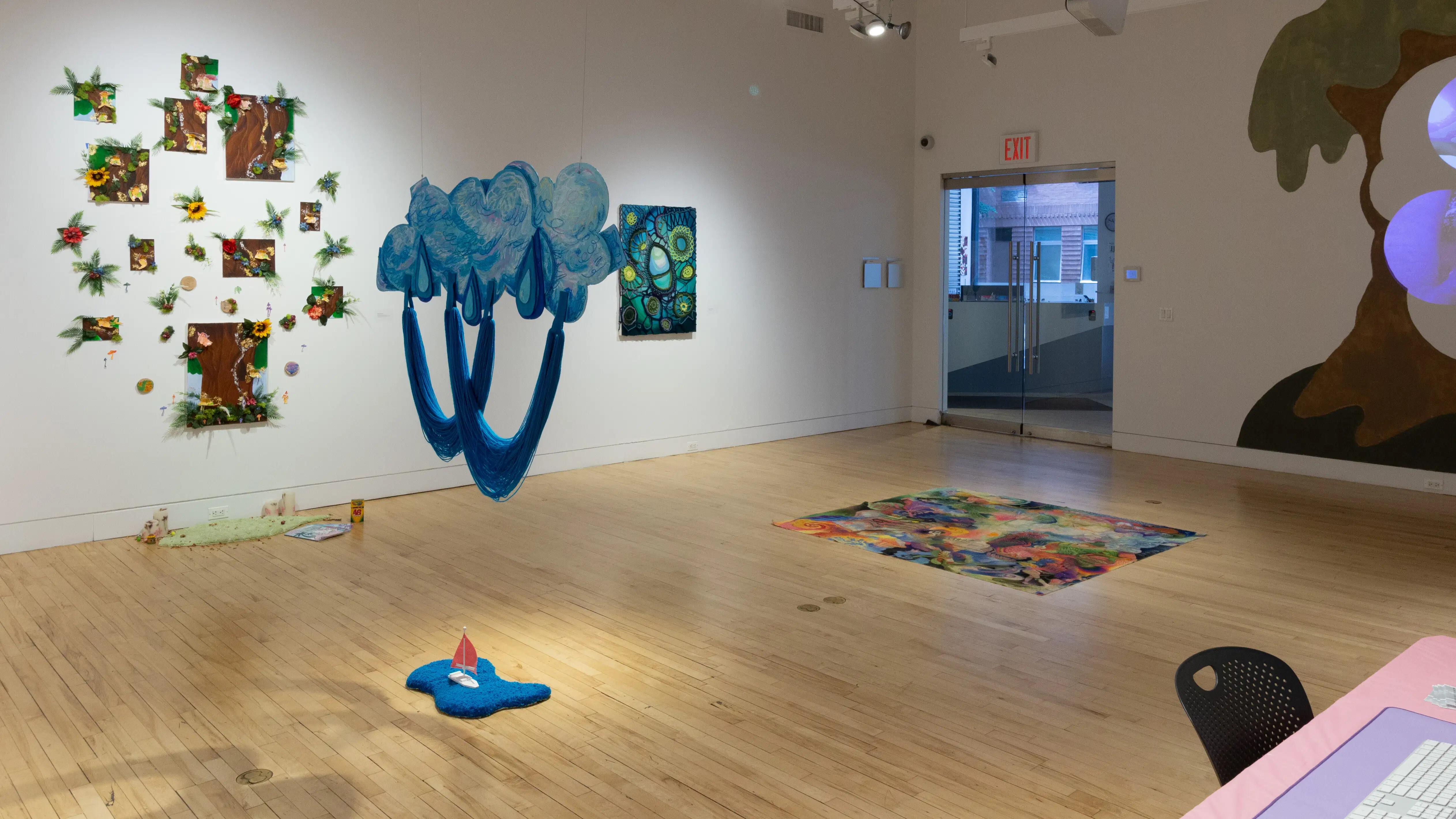 Multimedia artwork hanging in an art gallery from two walls and the ceiling.