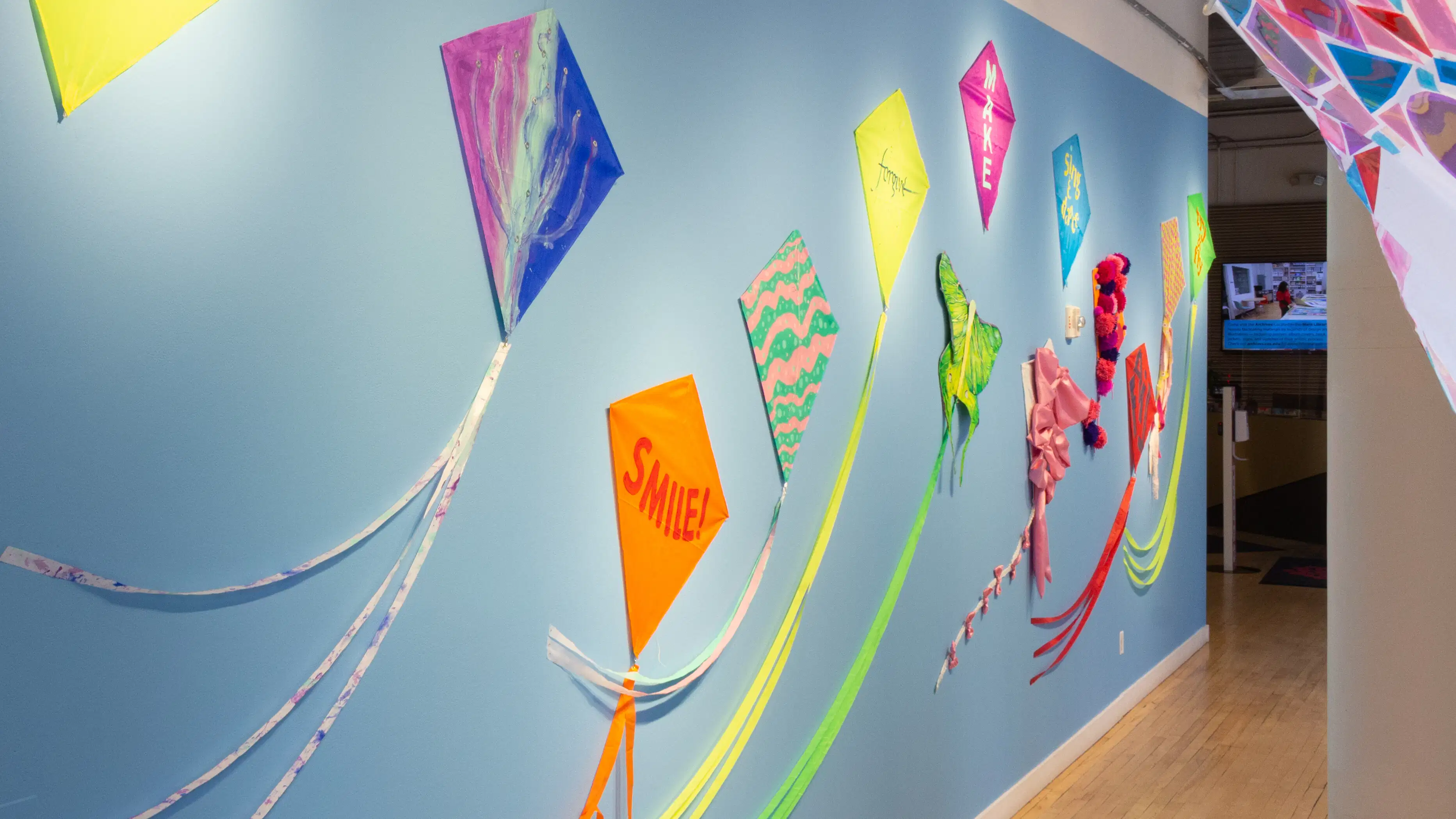 Hallway showing a blue painted wall with colorful kites.