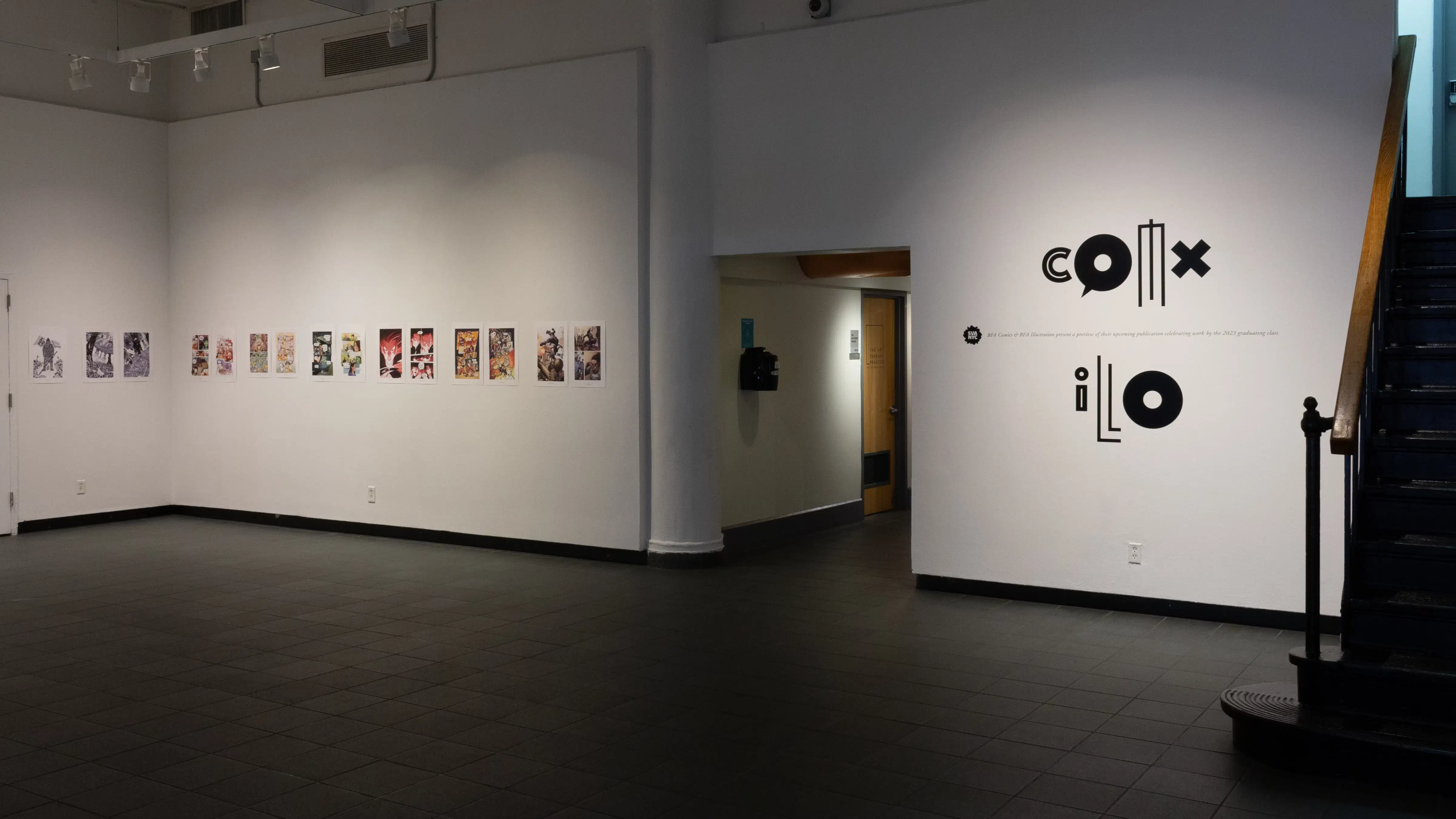 Install image showing a large entryway with vinyl on the wall saying, "ILLO COMX," and many prints lining the walls in a row.