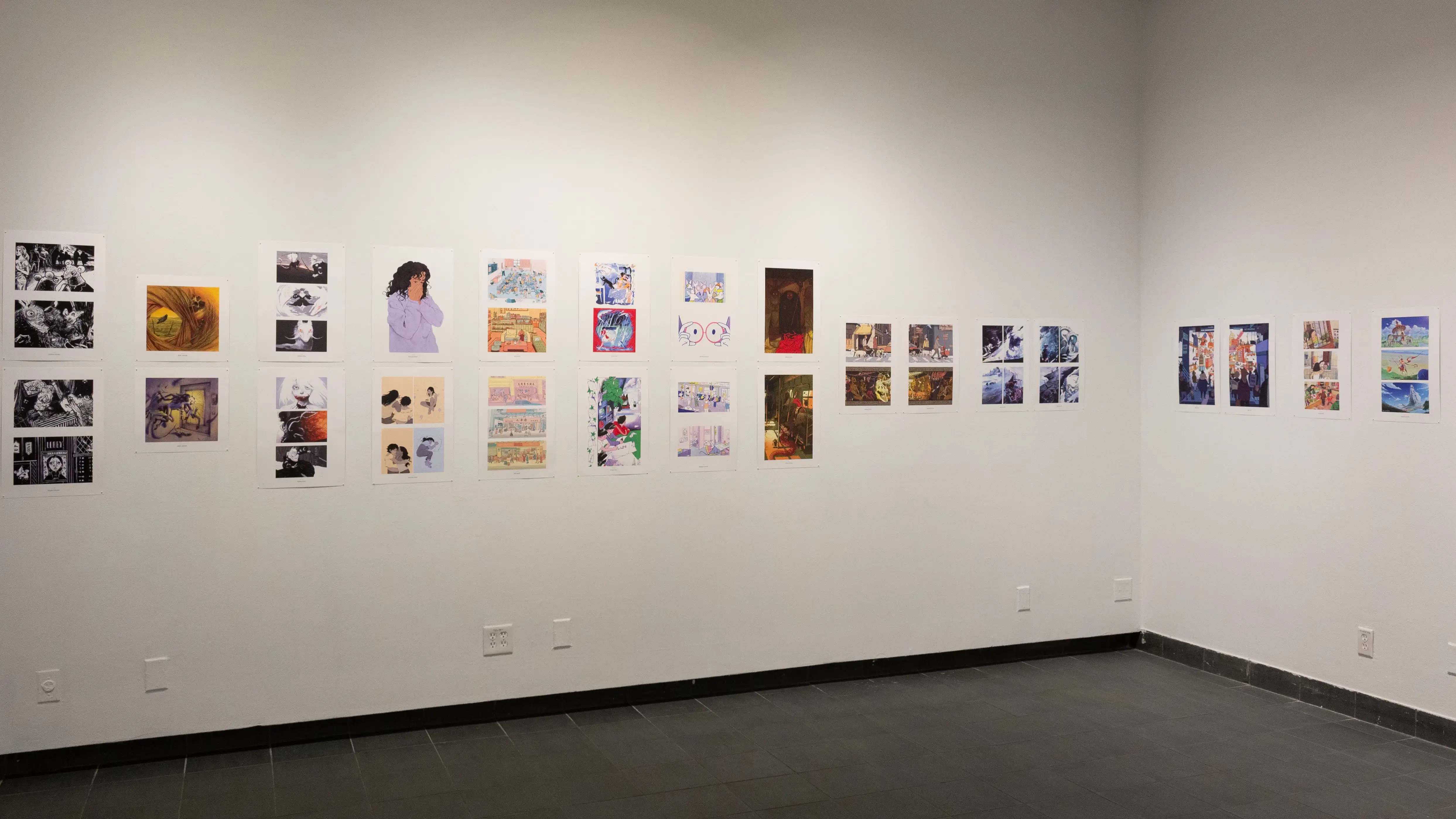 Install image showing an angled view of two large gallery walls with many prints lining the walls in a row.