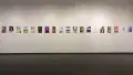 Install image showing a large gallery wall with many prints lining the walls in a row.