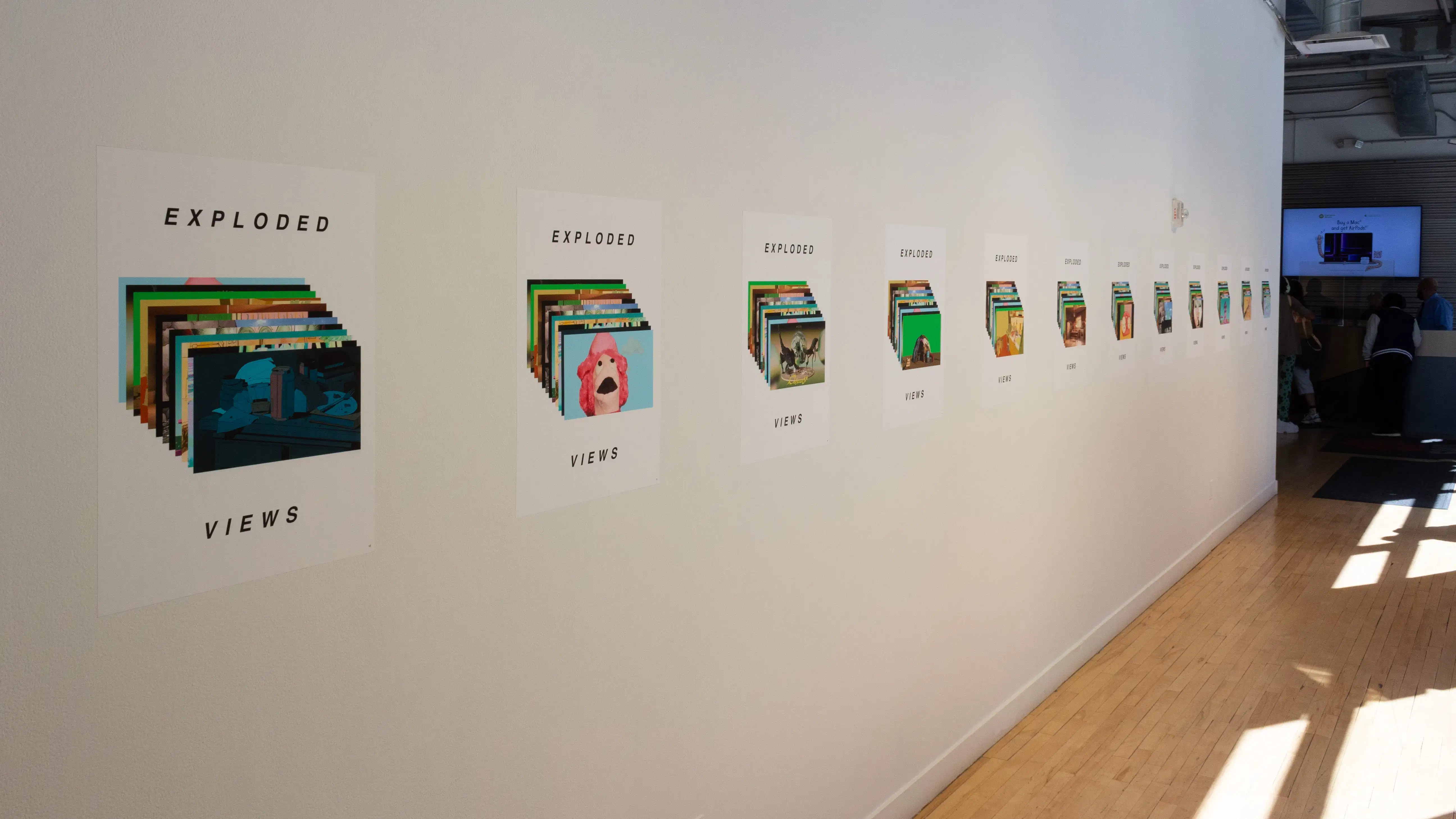 Installation image showing a long hall from the left, with a line of vinyl prints.