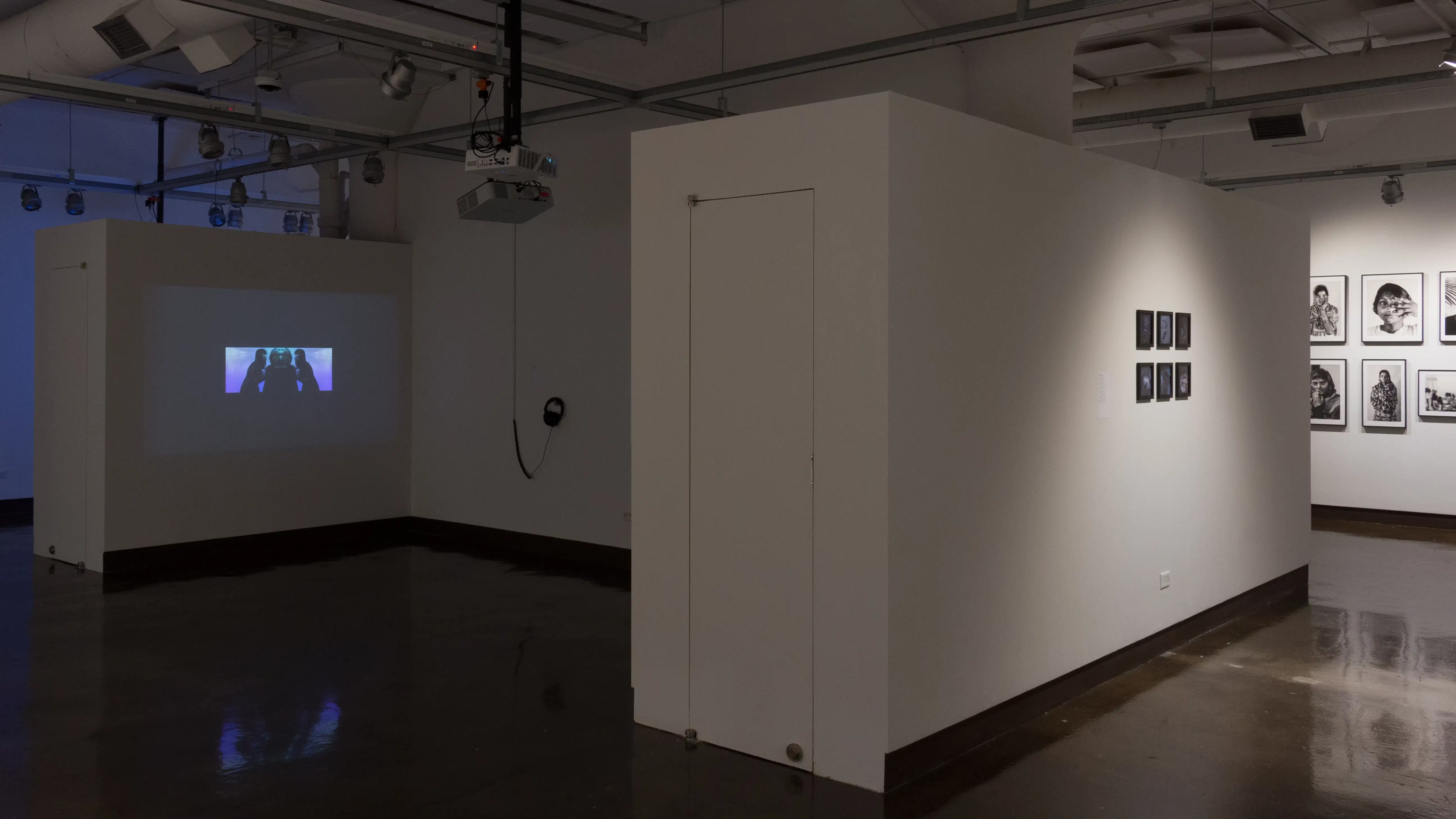 Gallery three is darker, with two projections directed onto the alcove walls. Six small framed photos are hung in the right hallway.