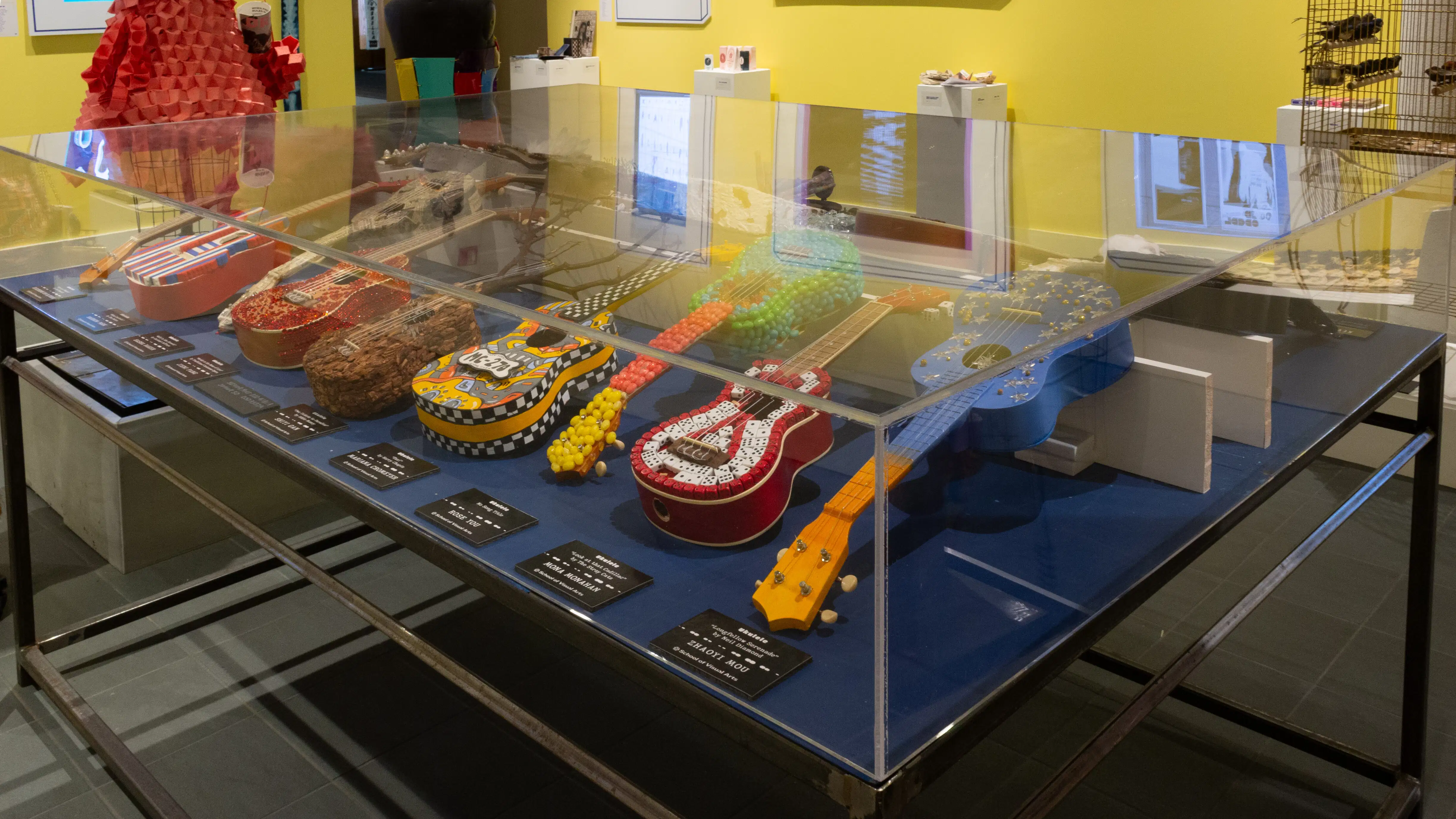 Alternate view inside the vitrine, where different ukuleles can be seen.