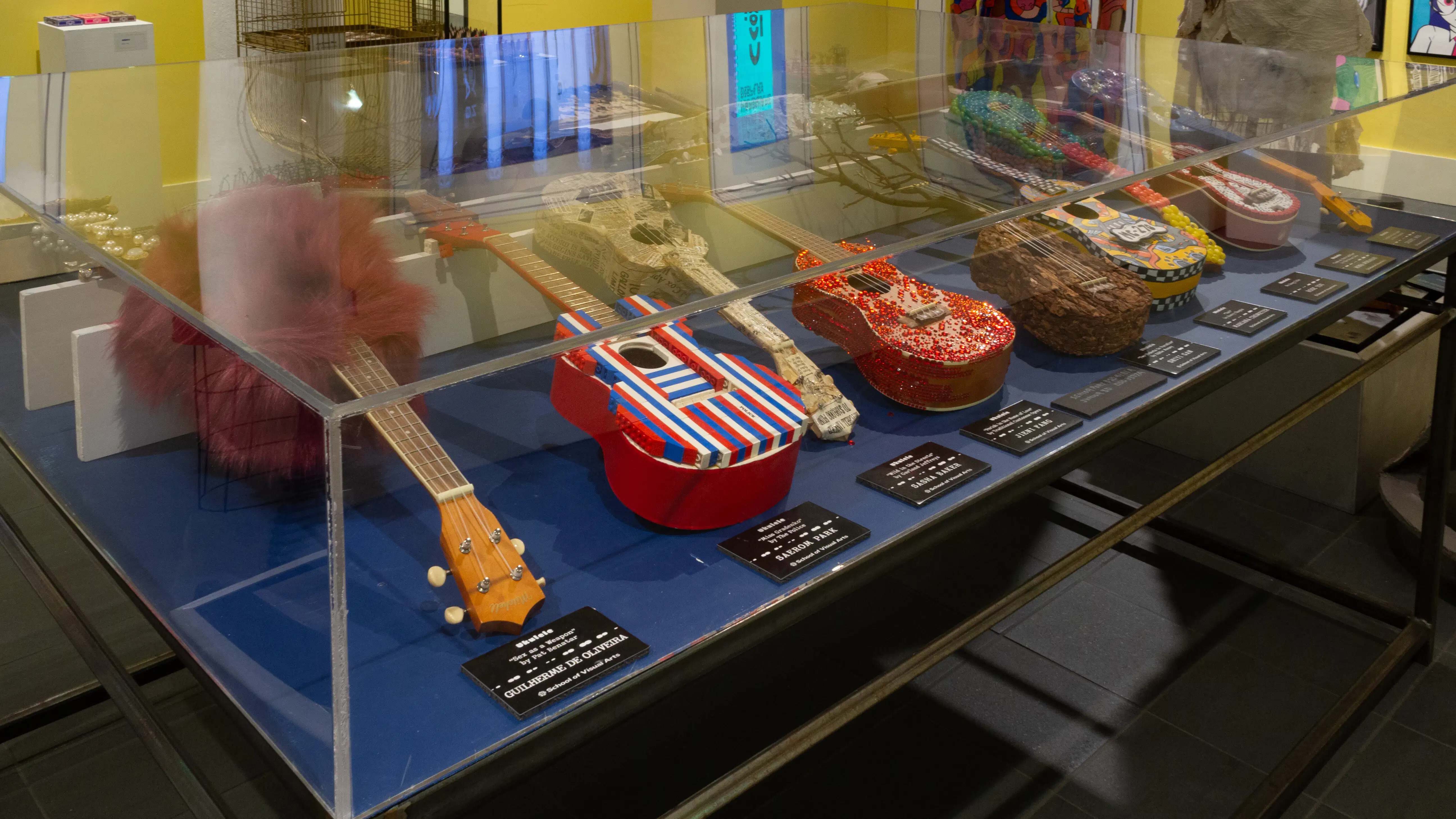 A third view of a different corner of the vitrine, where more ukuleles can be seen.