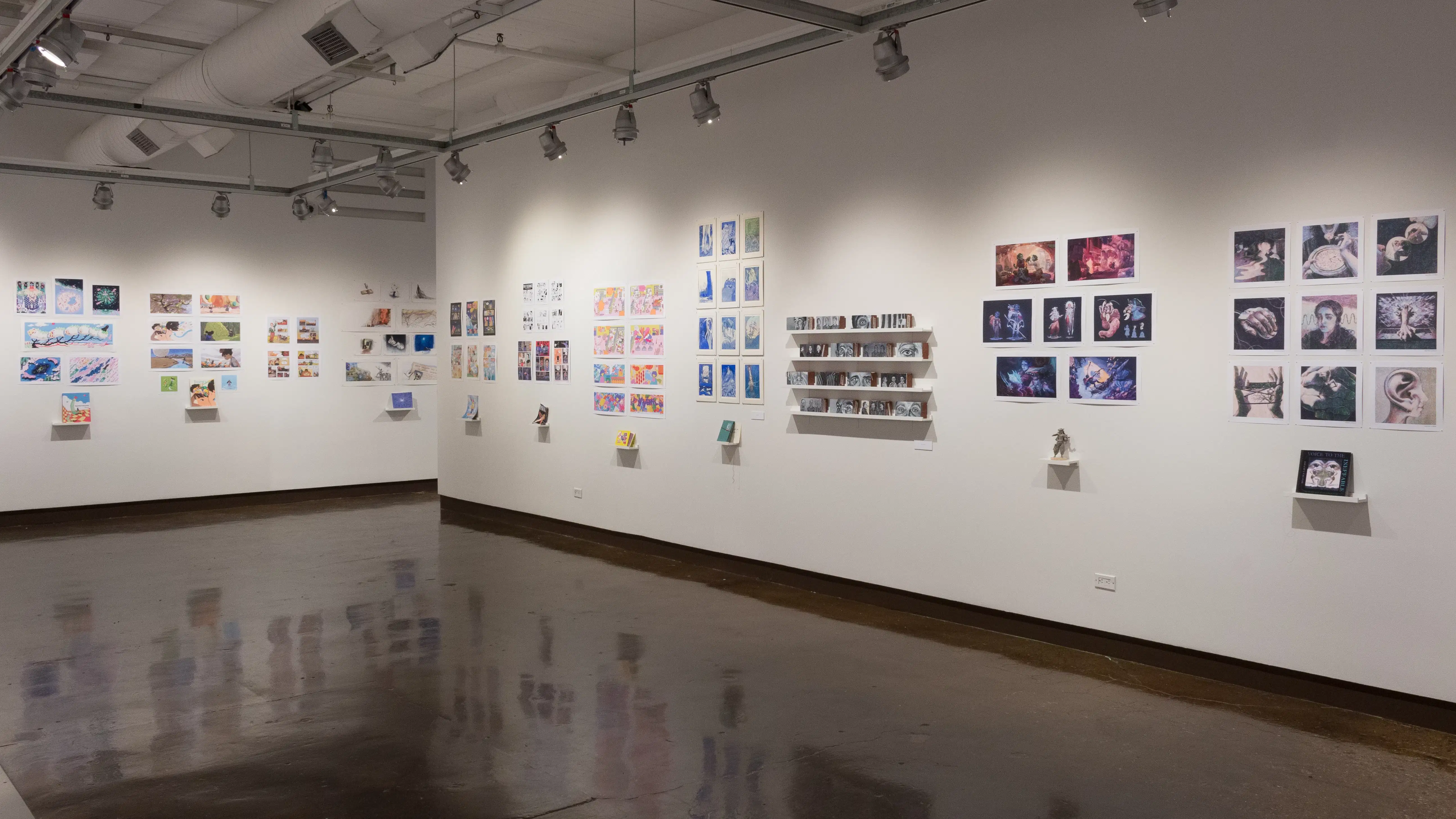 More prints are displayed above students’ books. One project does not have prints – Instead, several block-like sculptures sit on four shelves.