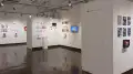 The third gallery space is visible from another angle. More student work can be seen on surrounding walls.