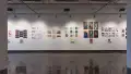 Prints, originals, and books are all displayed on a wall of gallery one.