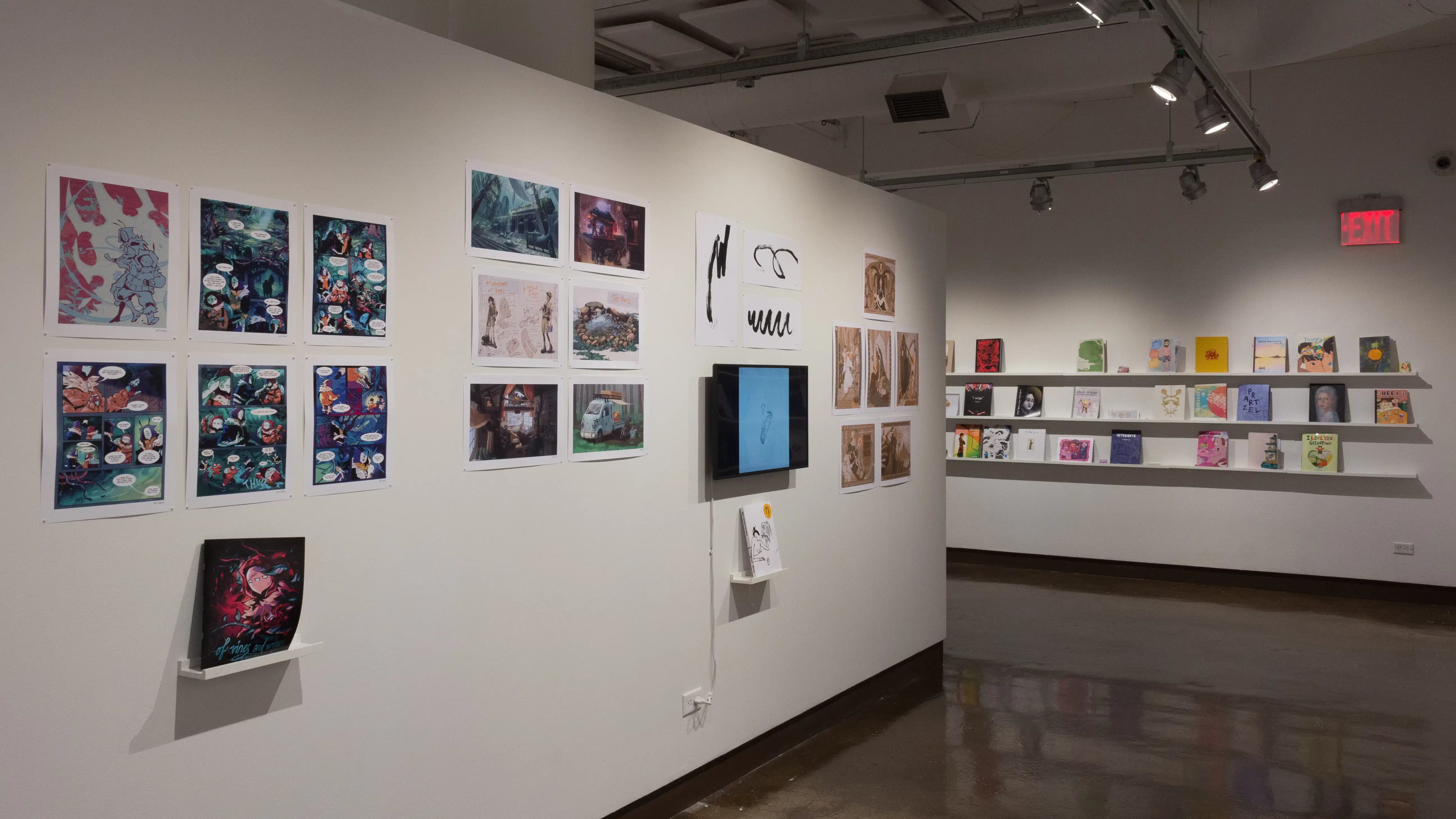 The prints hanging on the walls vary in dimension, style, and color. Books sit on shelves beneath the prints and a TV displays online works and animations. 