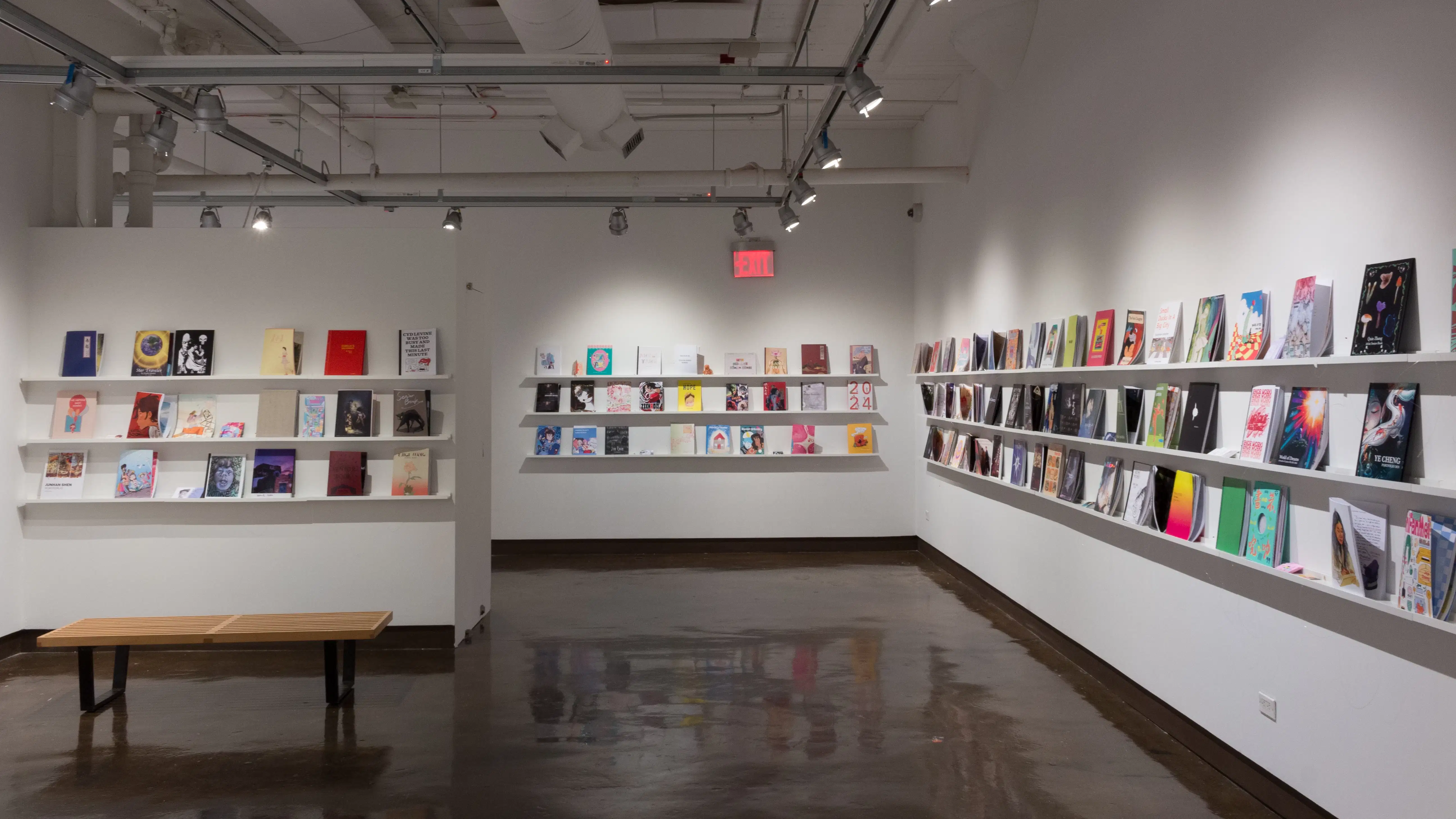 Colorful books are displayed in three rows, lining the walls of gallery four. 