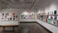 Colorful books are displayed in three rows, lining the walls of gallery four. 