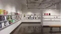 Colorful books are displayed in three rows lining the walls of gallery four. 