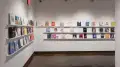 Corner view of colorful books that are displayed in three rows lining the walls of gallery four. 