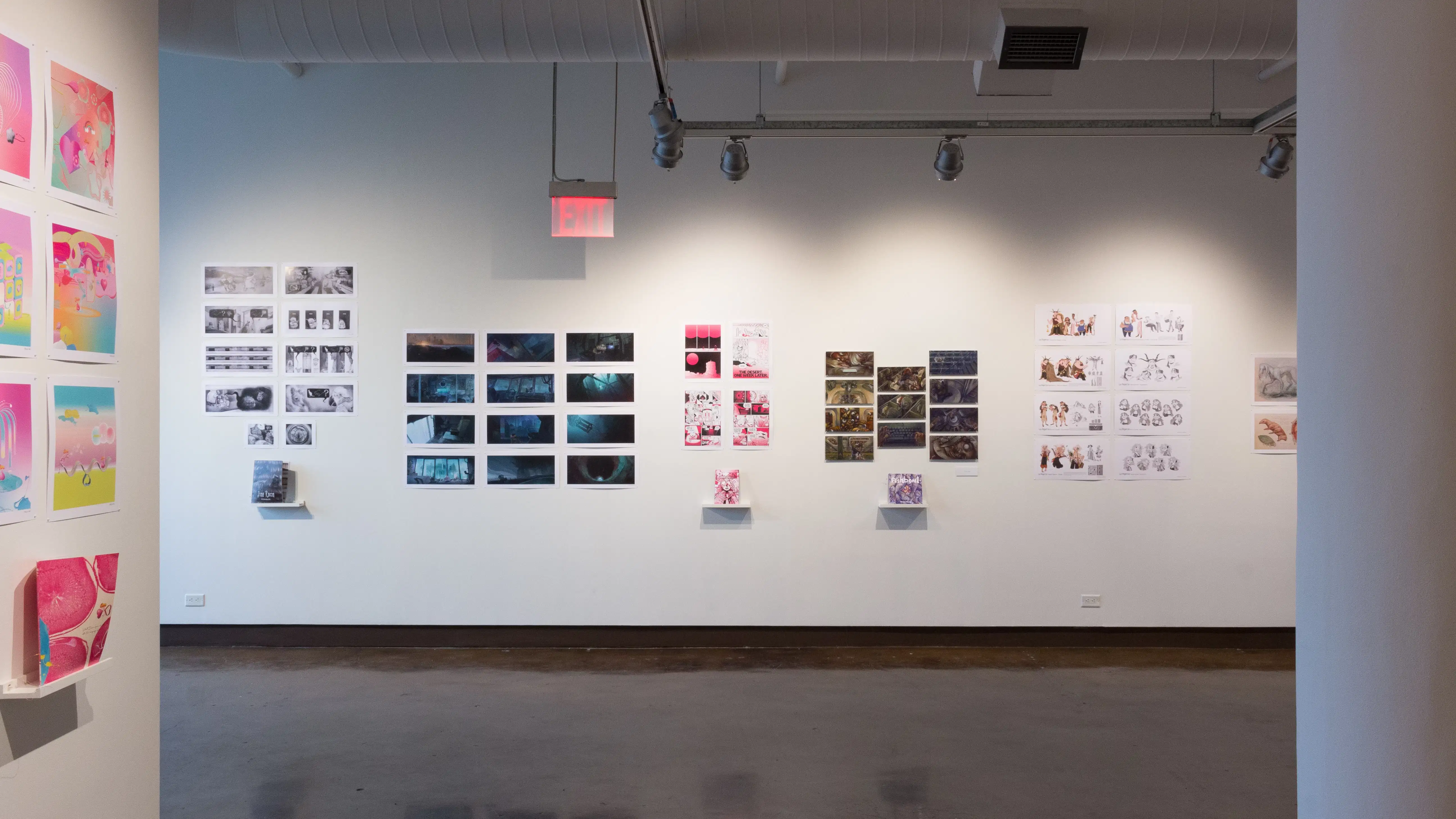 Prints, originals, and books are all displayed on a wall of gallery one.