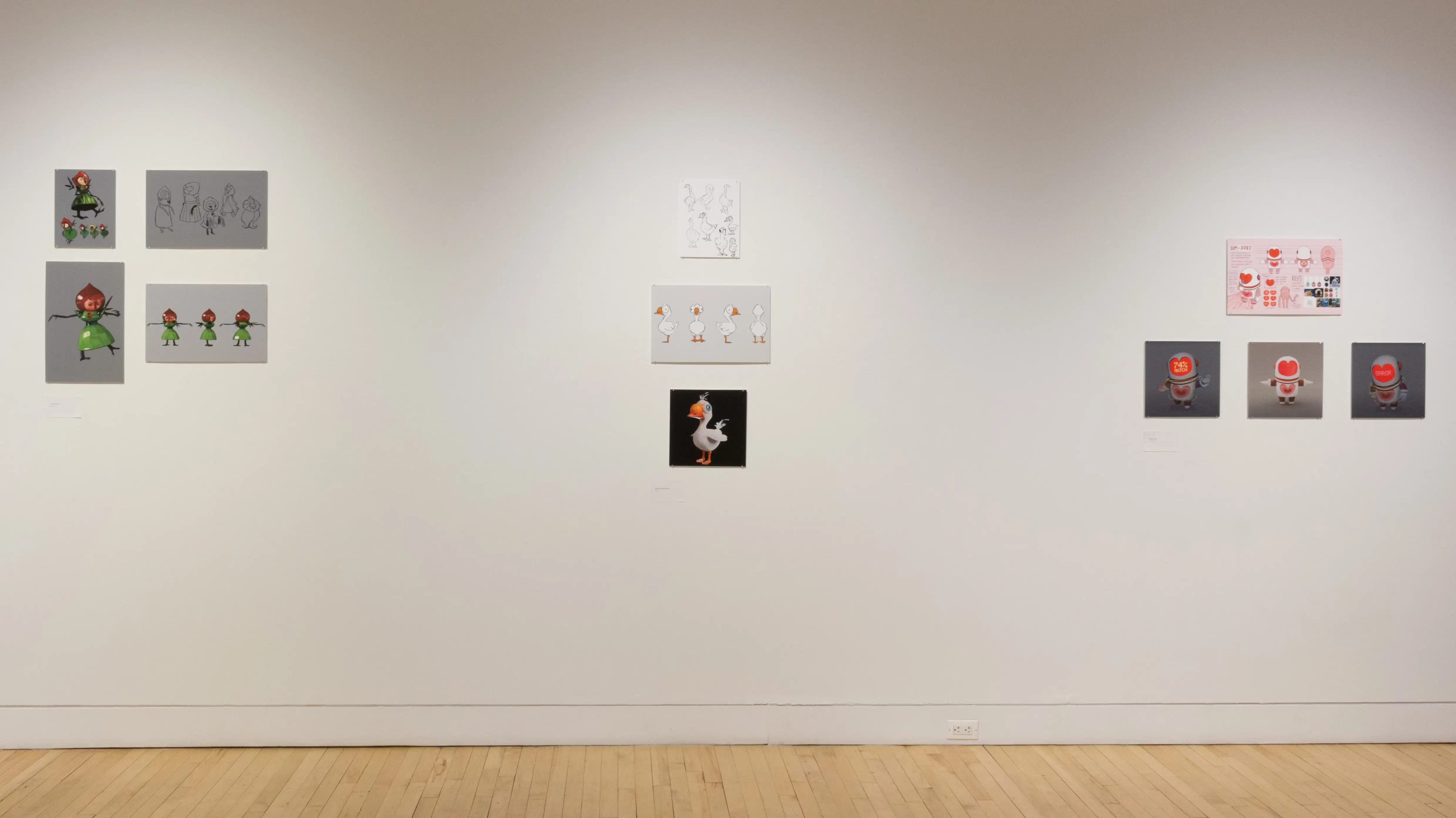  Front view of three student works on the side wall, showing printed mockups of animated characters. 